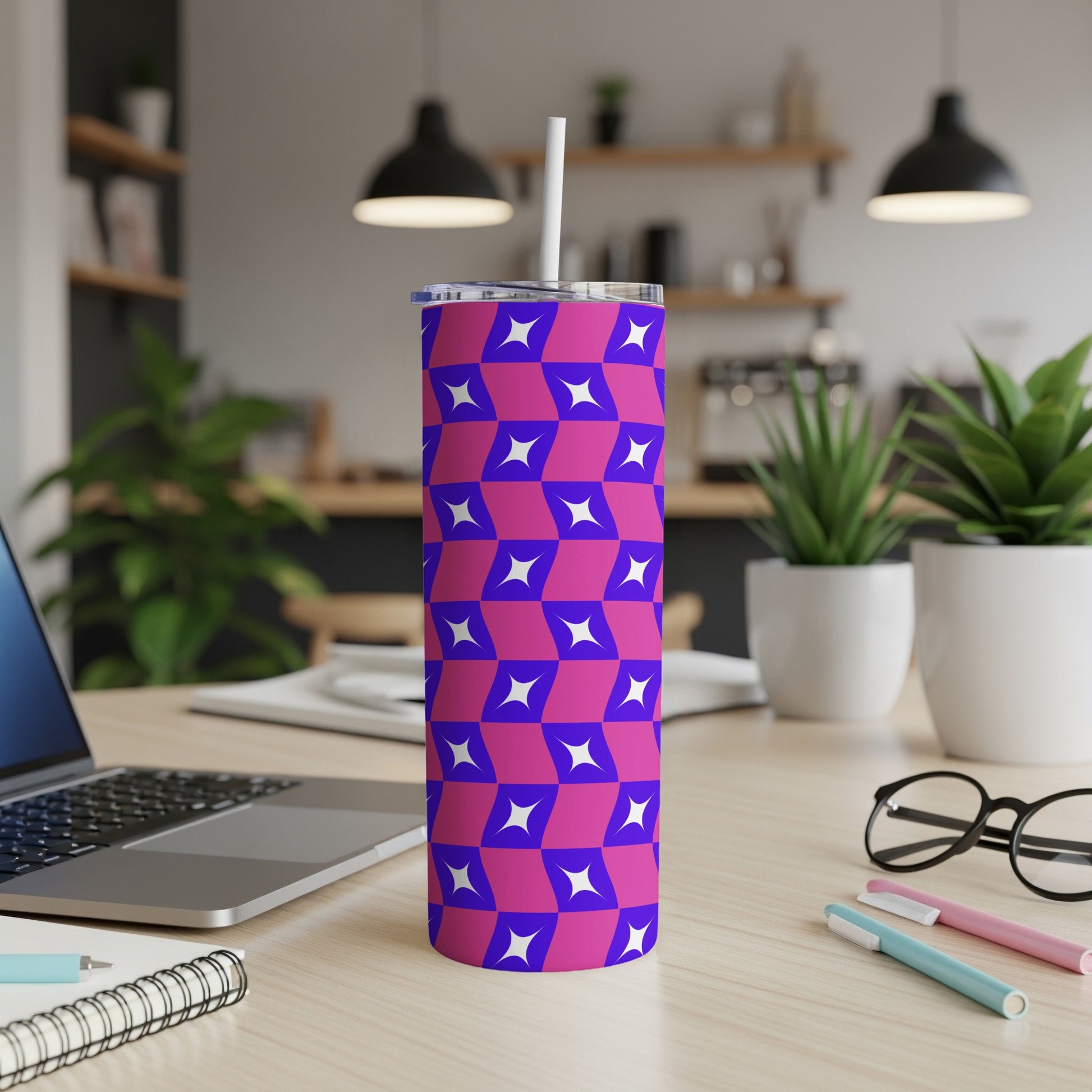 Purple and blue geometric tumbler with straw on a desk.