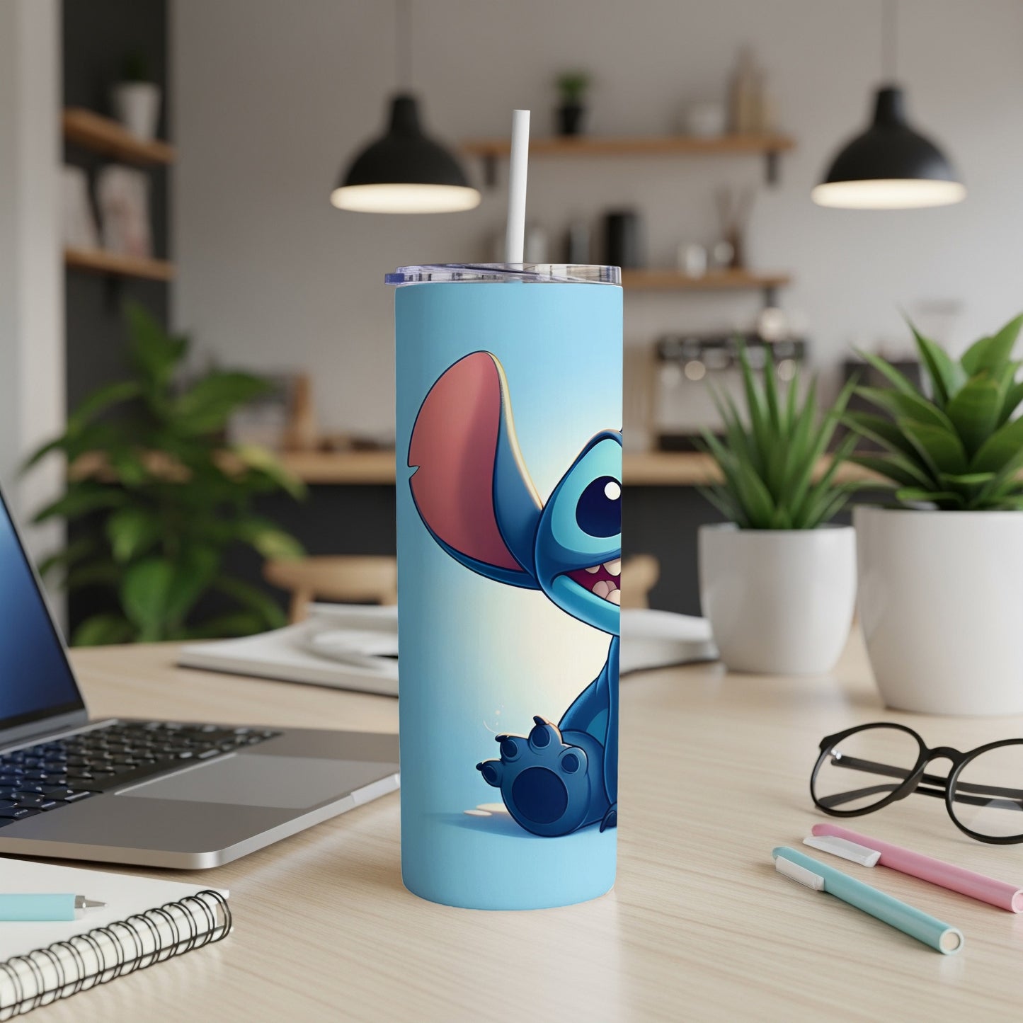 Blue Stitch character on a light blue tumbler with straw, on a desk.