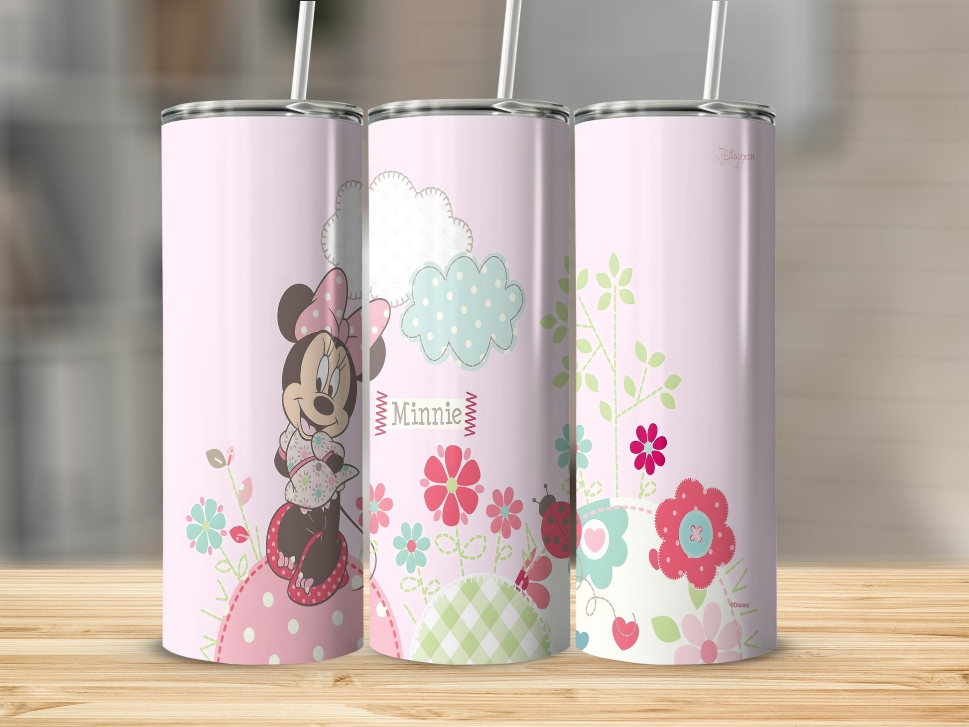 Minnie Mouse with flowers and clouds on a pink patterned tumbler.