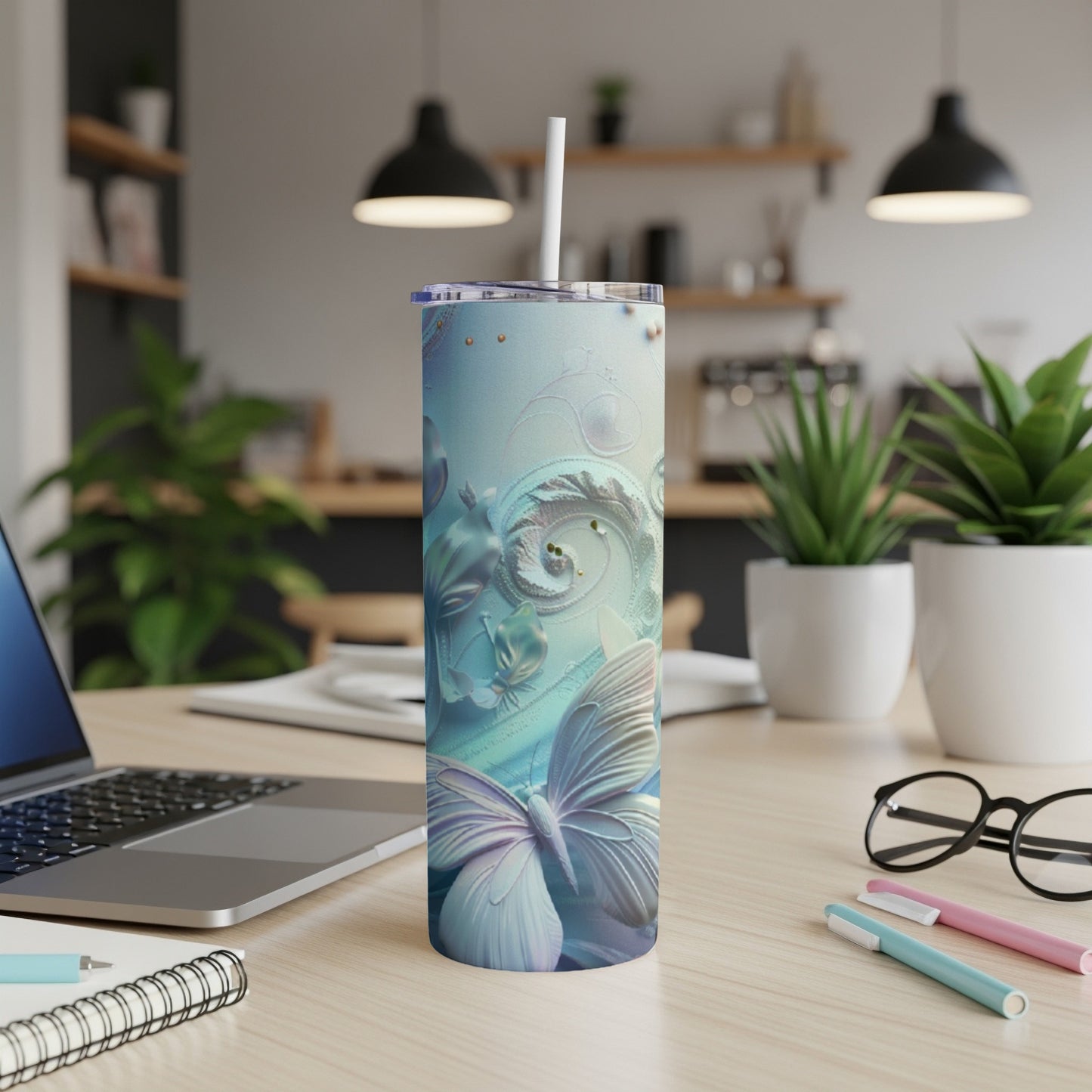 Butterfly and floral abstract design on a blue tumbler with a straw.