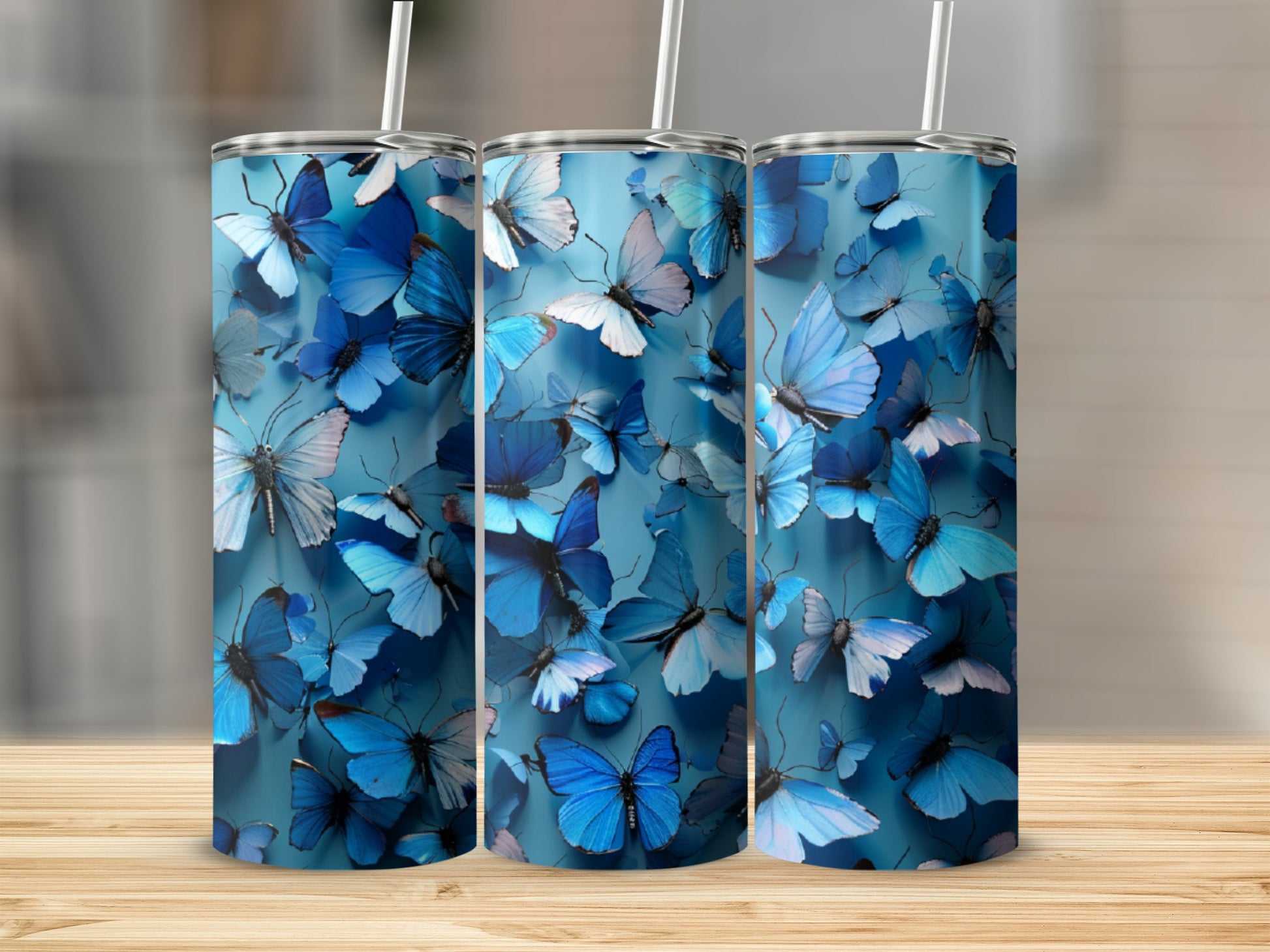Three blue tumblers with a pattern of blue butterflies.
