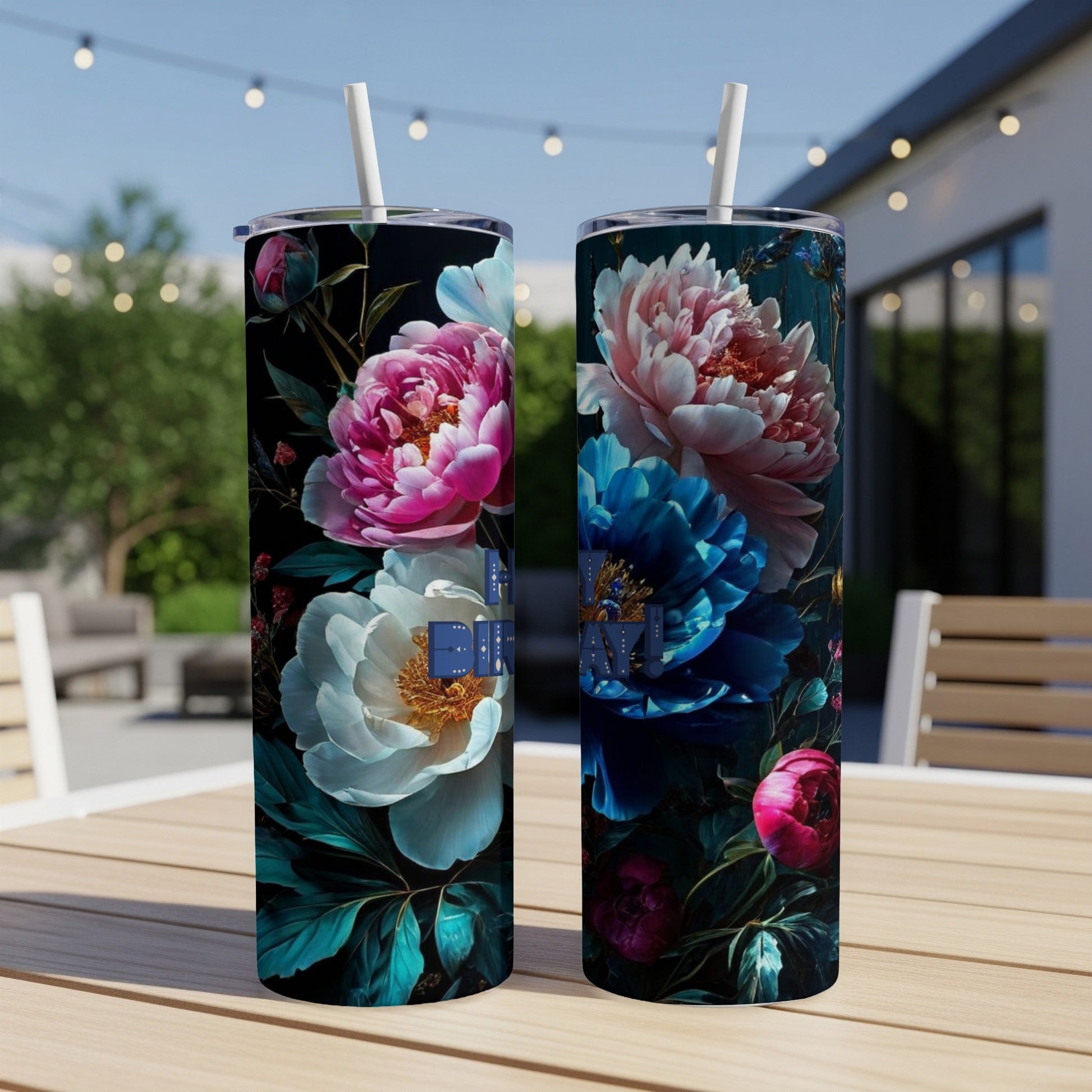 Two tumblers with vibrant floral designs, one blue and one pink, on a table.