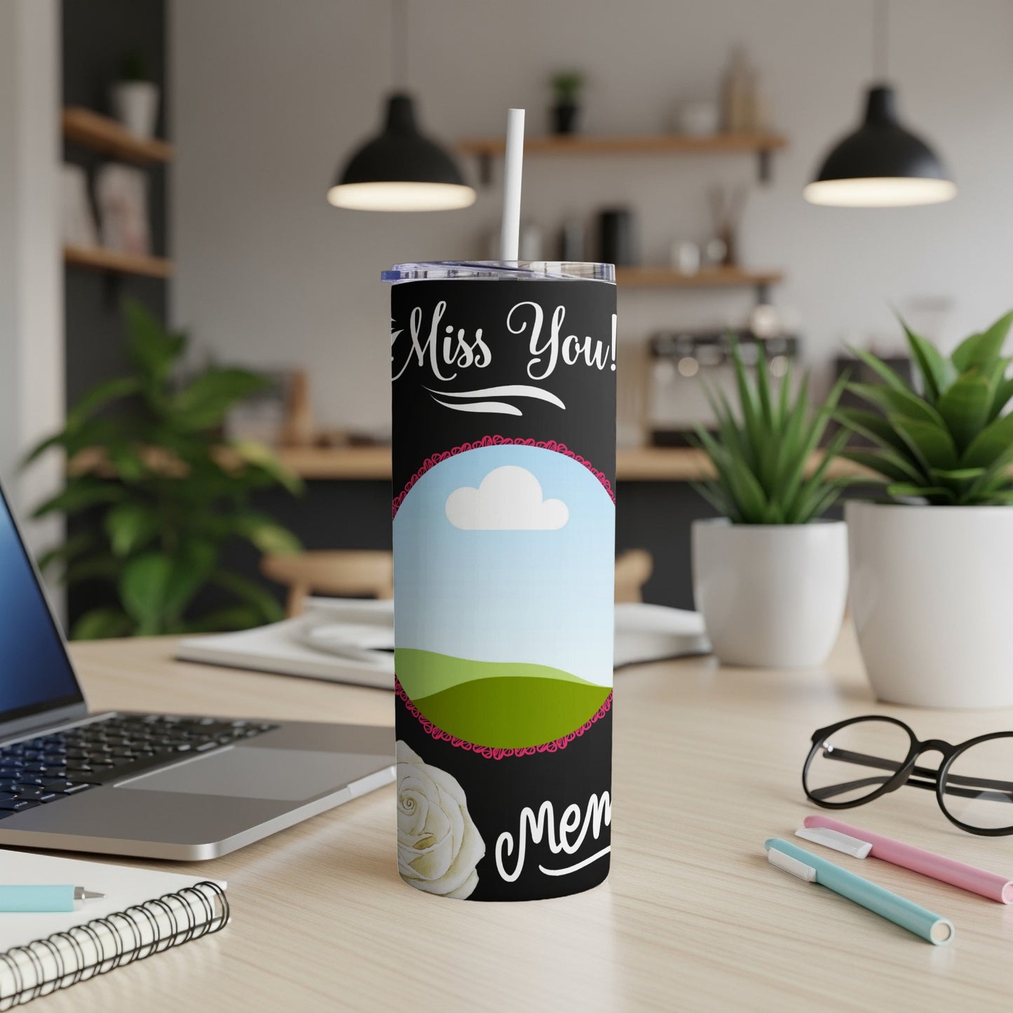 Black tumbler with "Miss You!" text, a framed landscape, and a white rose.