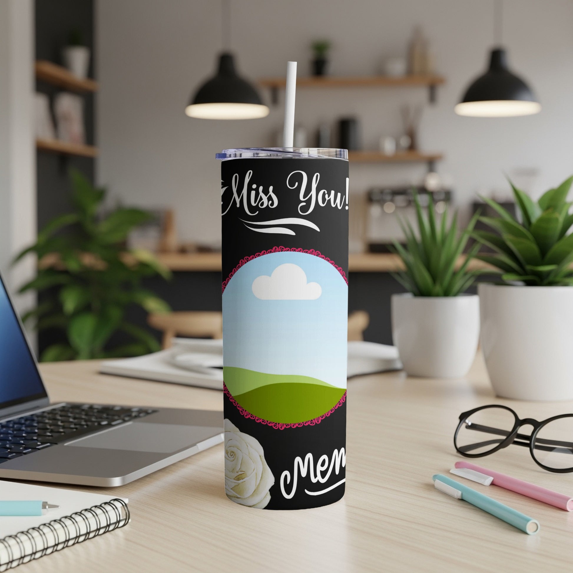 Black tumbler with "Miss You!" text, a framed landscape, and a white rose.