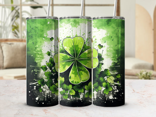 Green four-leaf clover tumbler with speckled background and straw.