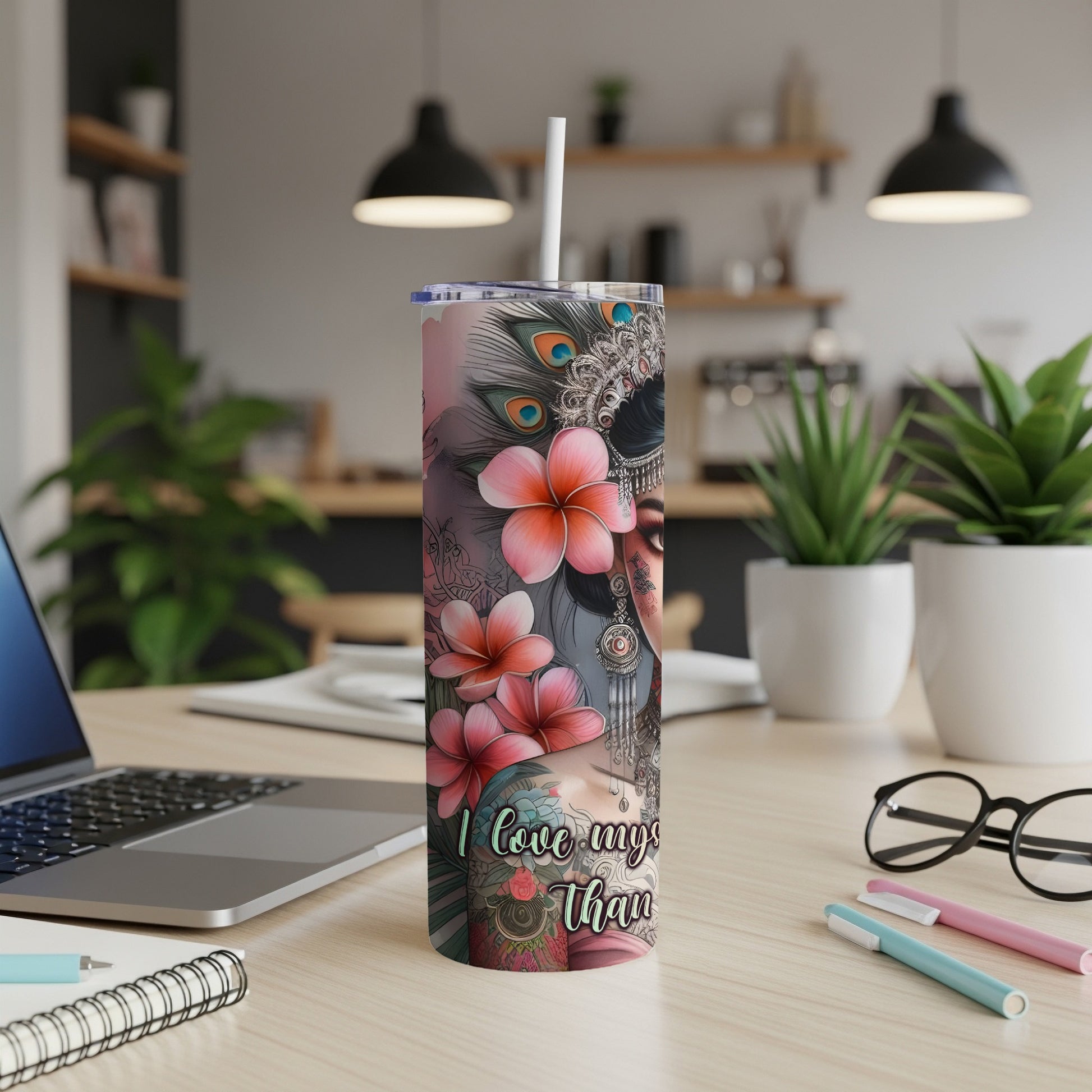 Tumbler with floral and peacock feather design, featuring a woman's face.