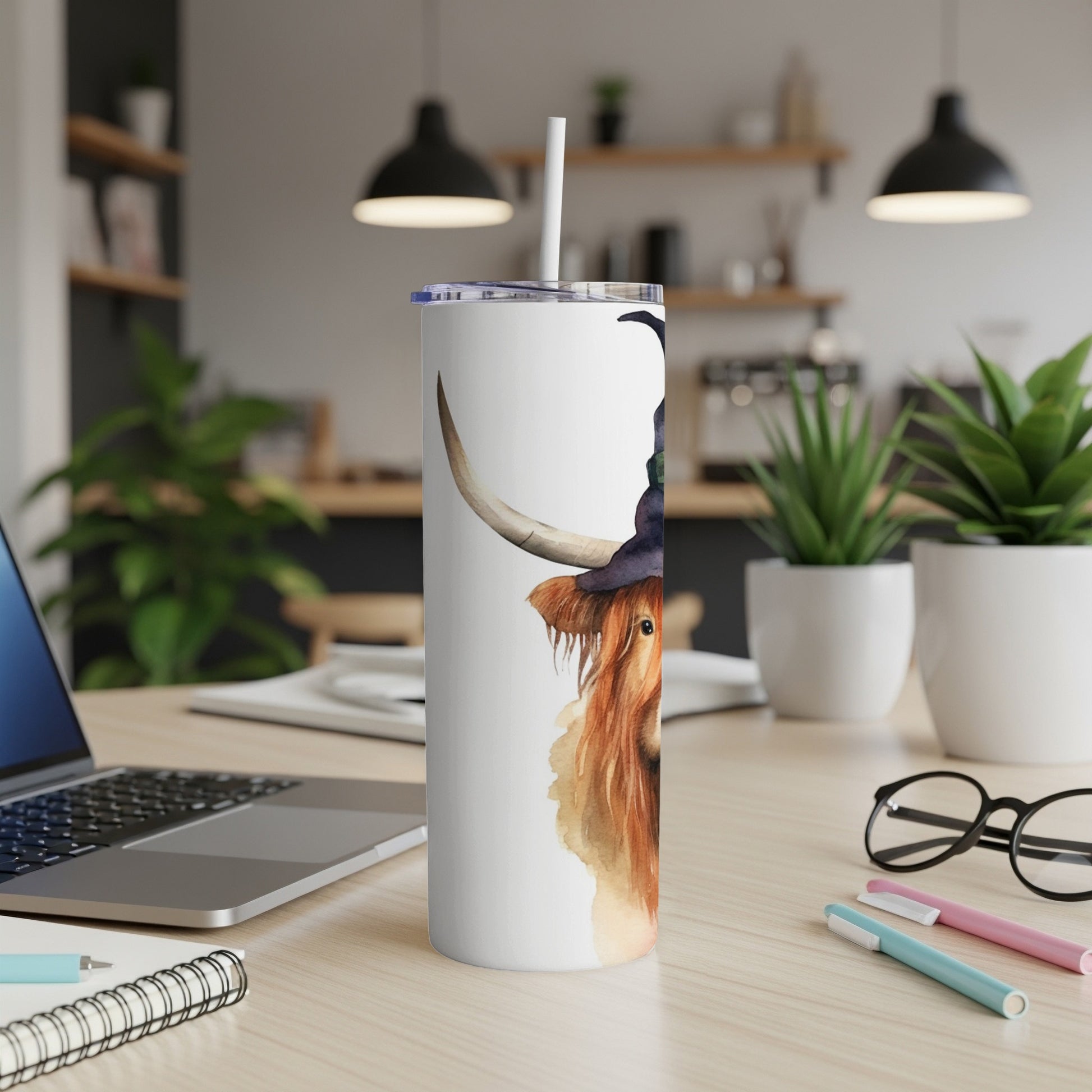 White tumbler with a watercolor painting of a Highland cow wearing a witch hat.