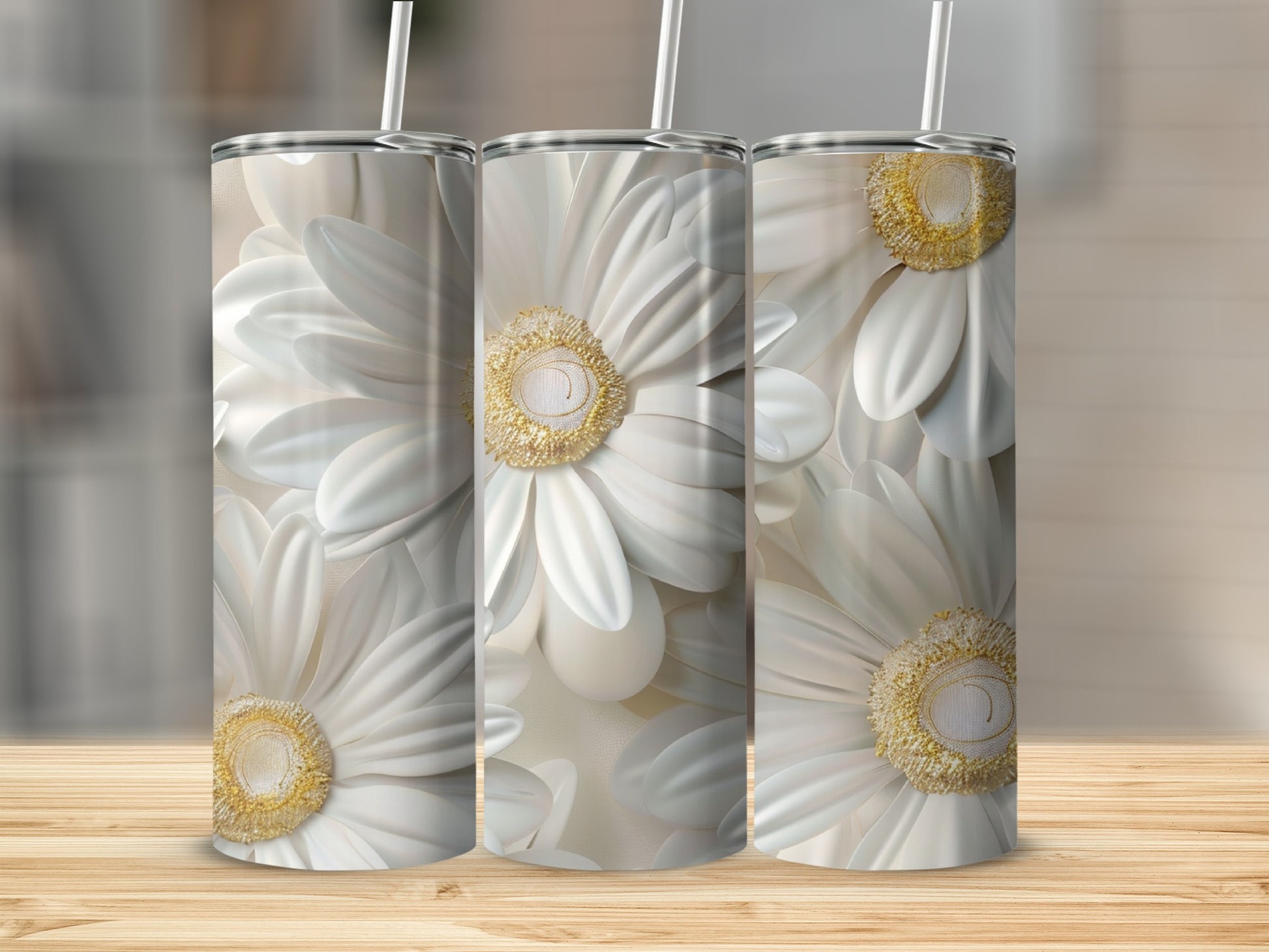 Three tumblers with white floral designs stand on a wooden surface.