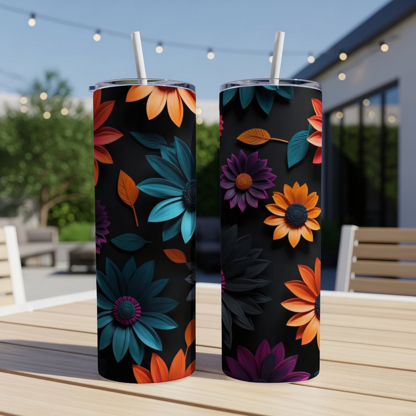 Two tumblers with colorful floral designs on a table outdoors.