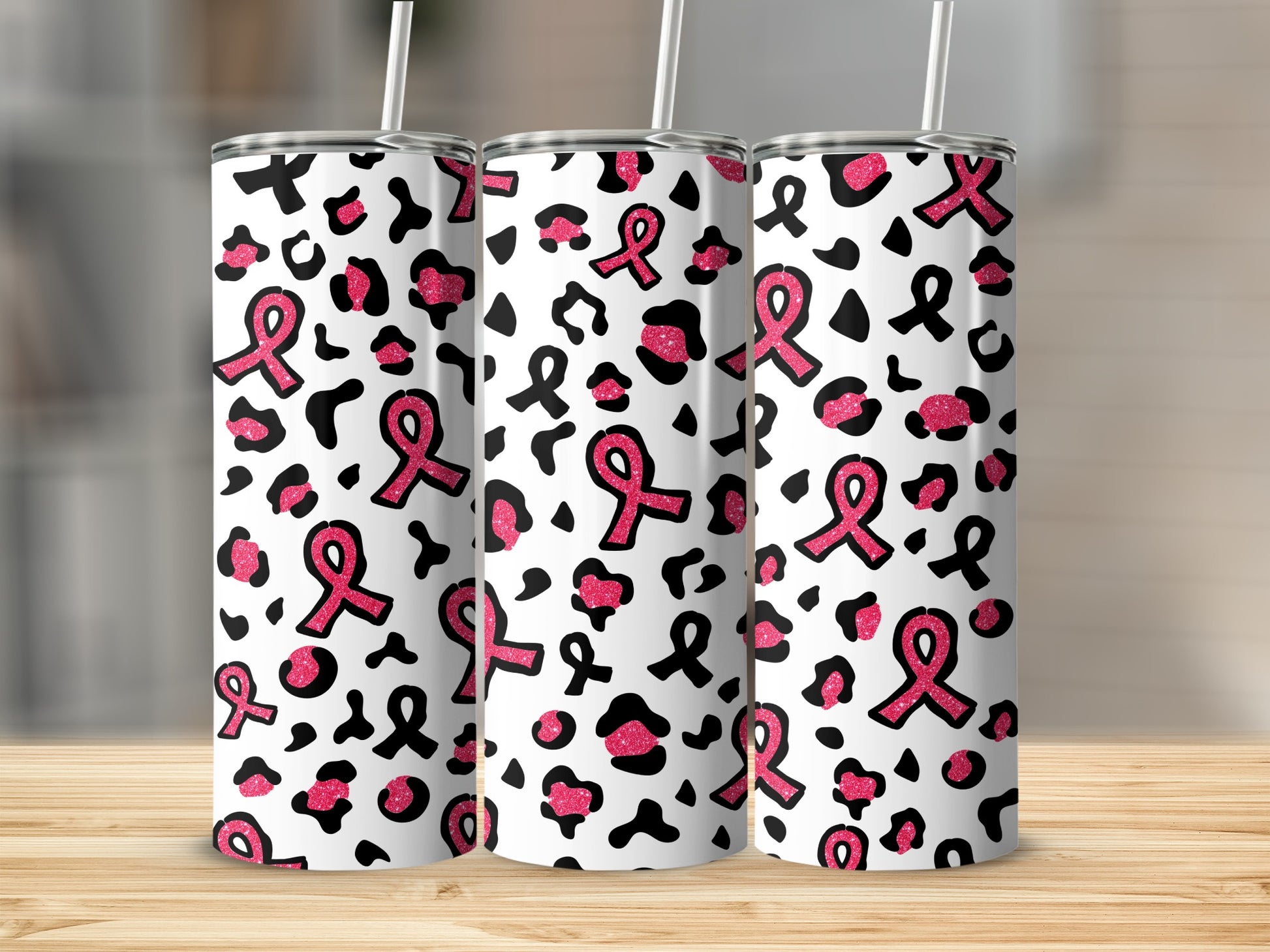 Three tumblers with pink breast cancer ribbons and leopard print design.