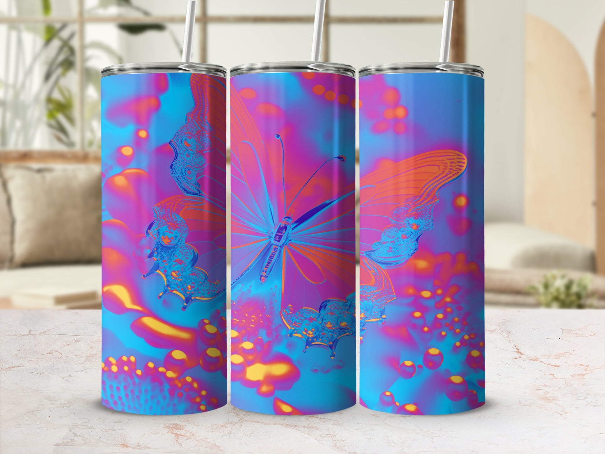 Three tumblers with vibrant blue, pink, and yellow butterfly and abstract designs.