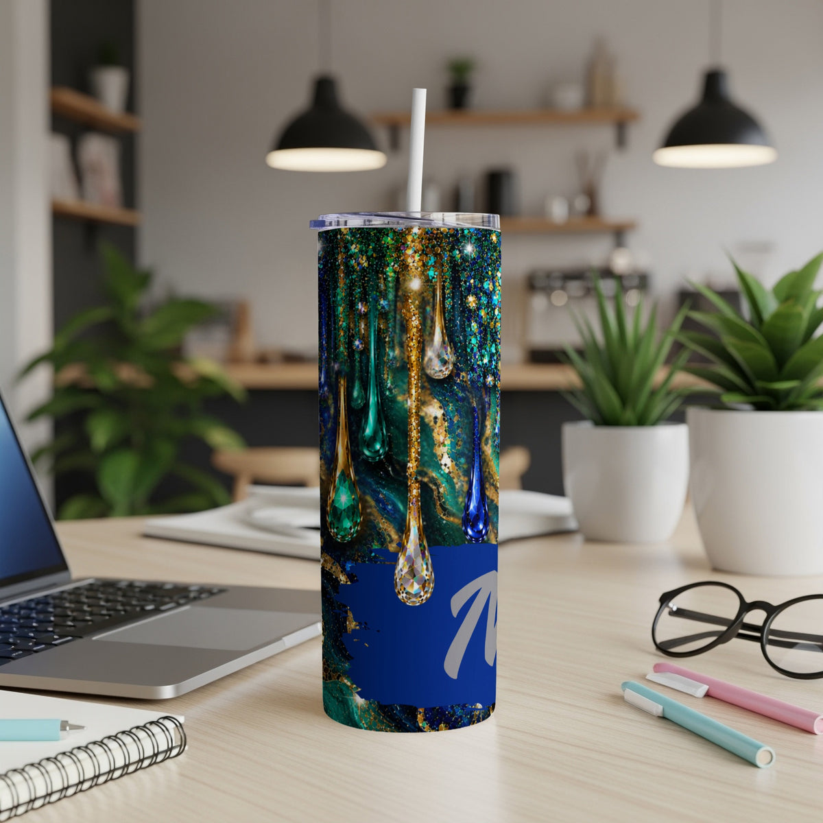 Tumbler with blue and green marbling, gold glitter, and dripping jewel designs.