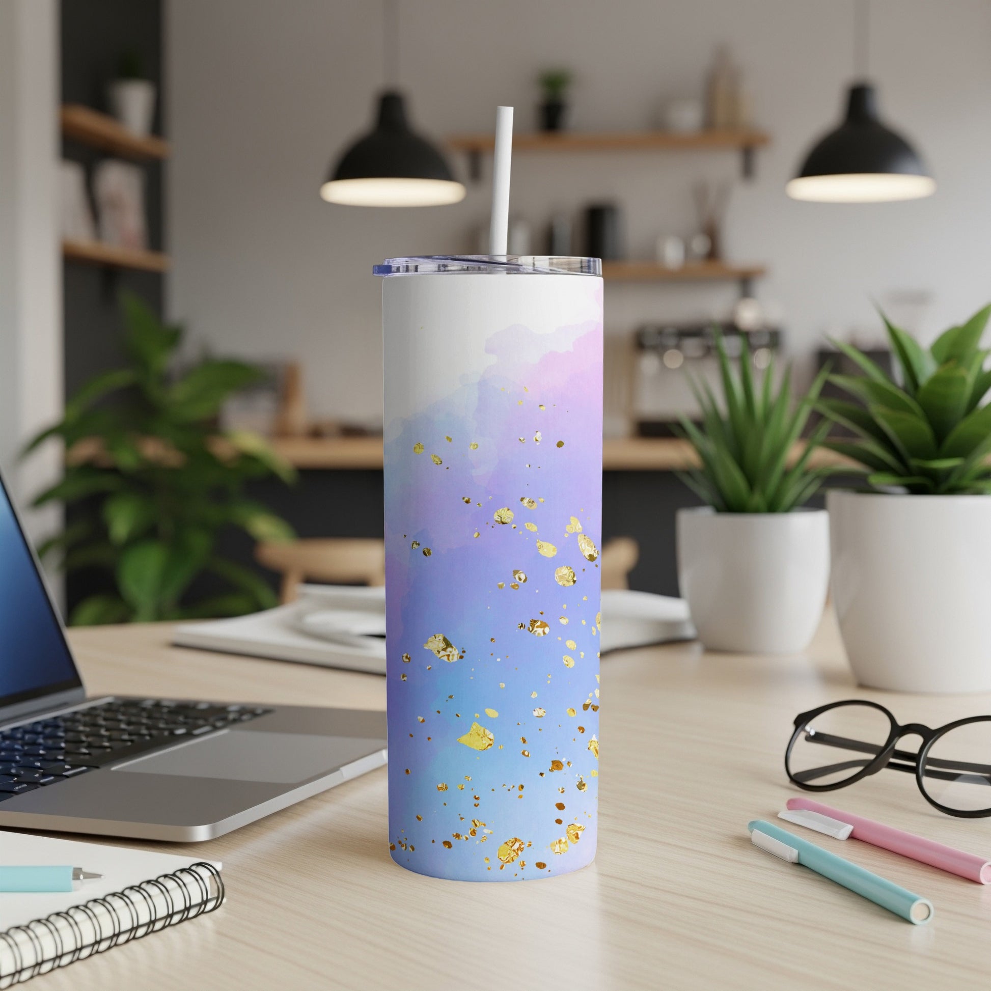 White tumbler with blue, purple, and gold watercolor design and straw.