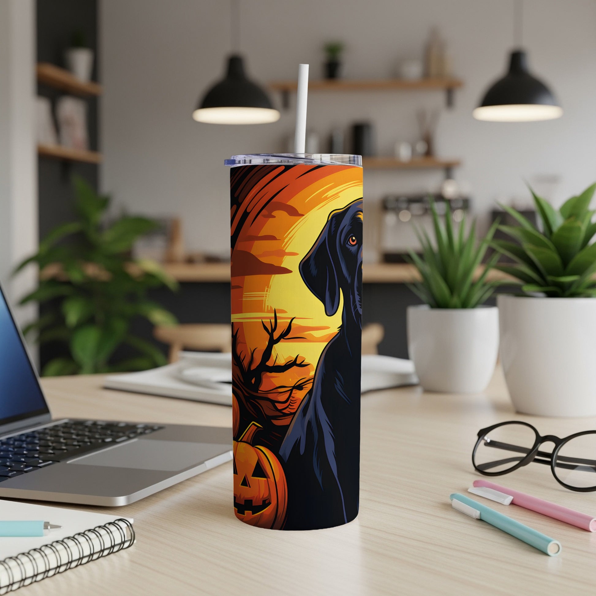 Black dog and jack-o'-lantern on a Halloween-themed tumbler with a straw.