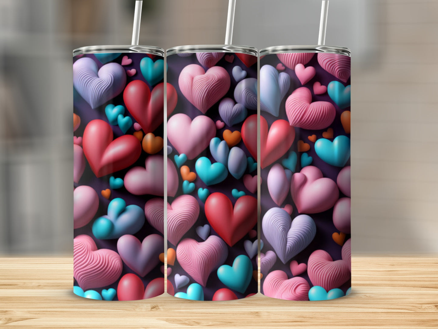 Three tumblers with a colorful heart pattern, set on a wooden surface.
