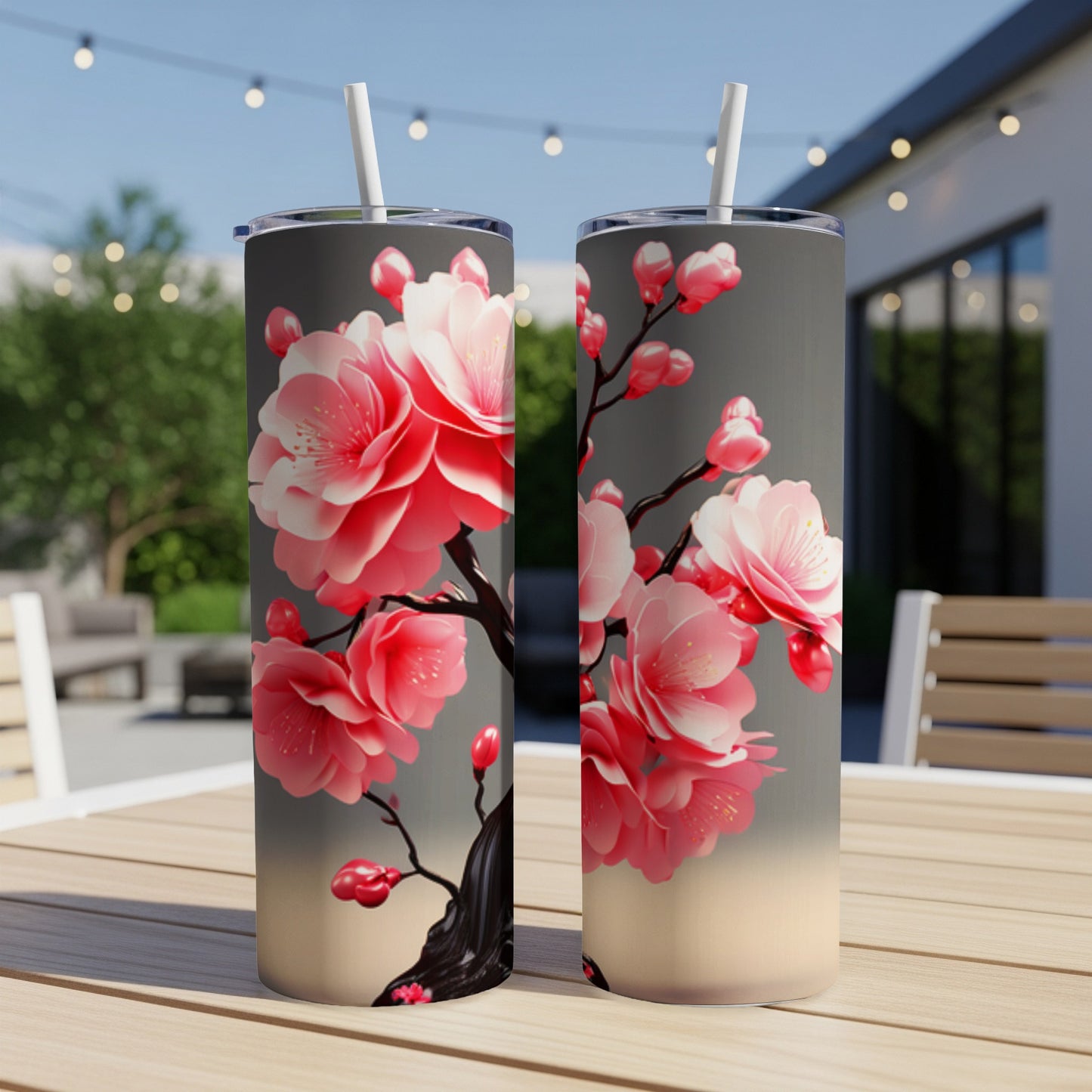 Two tall tumblers with pink cherry blossoms on a grey background.