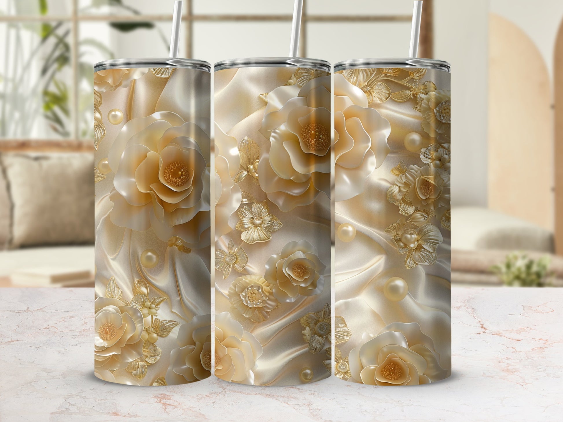 Triptych of tumblers with ornate gold floral and pearl designs on satin.