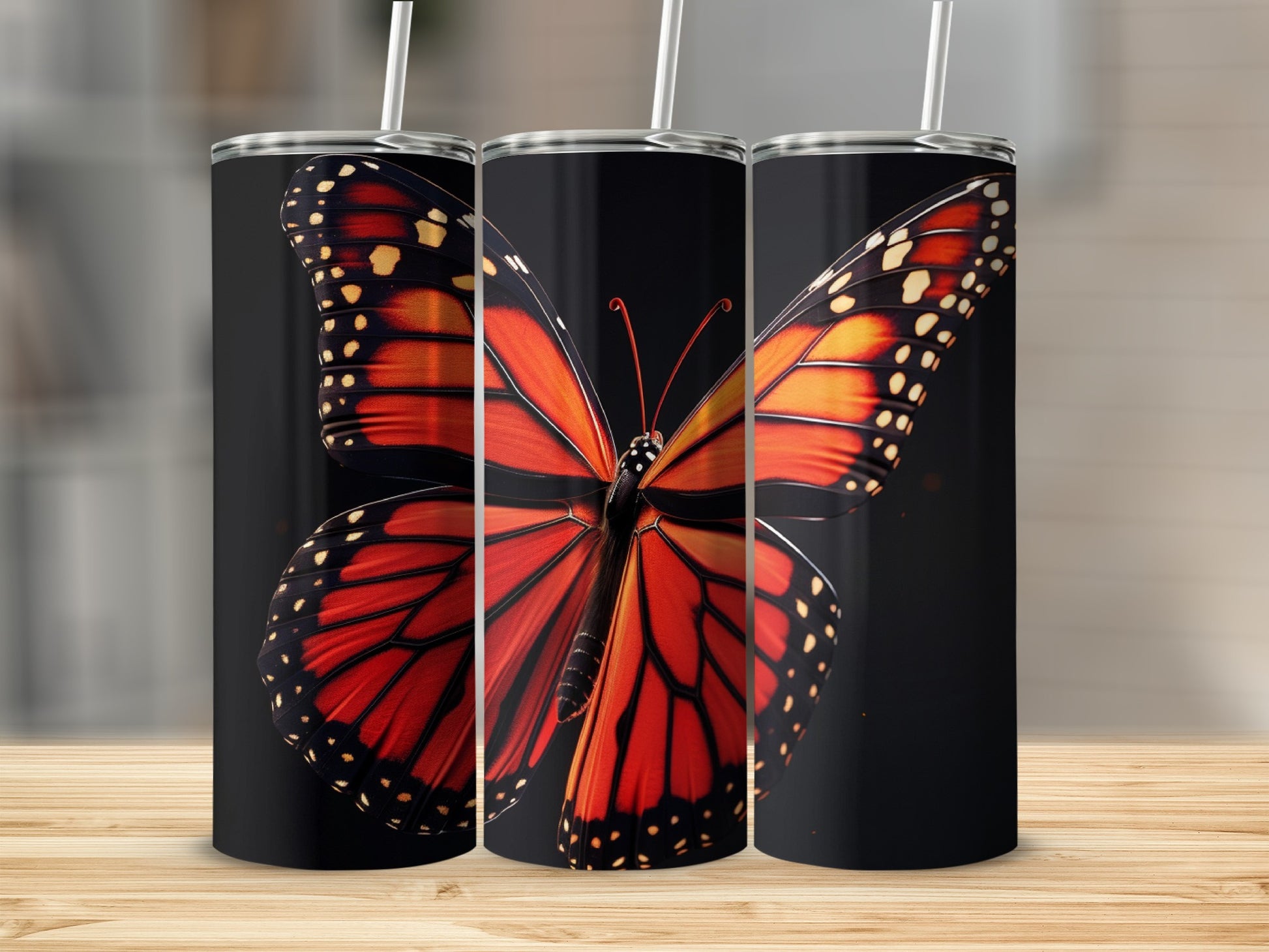 Three tumblers featuring a monarch butterfly design on a black background.