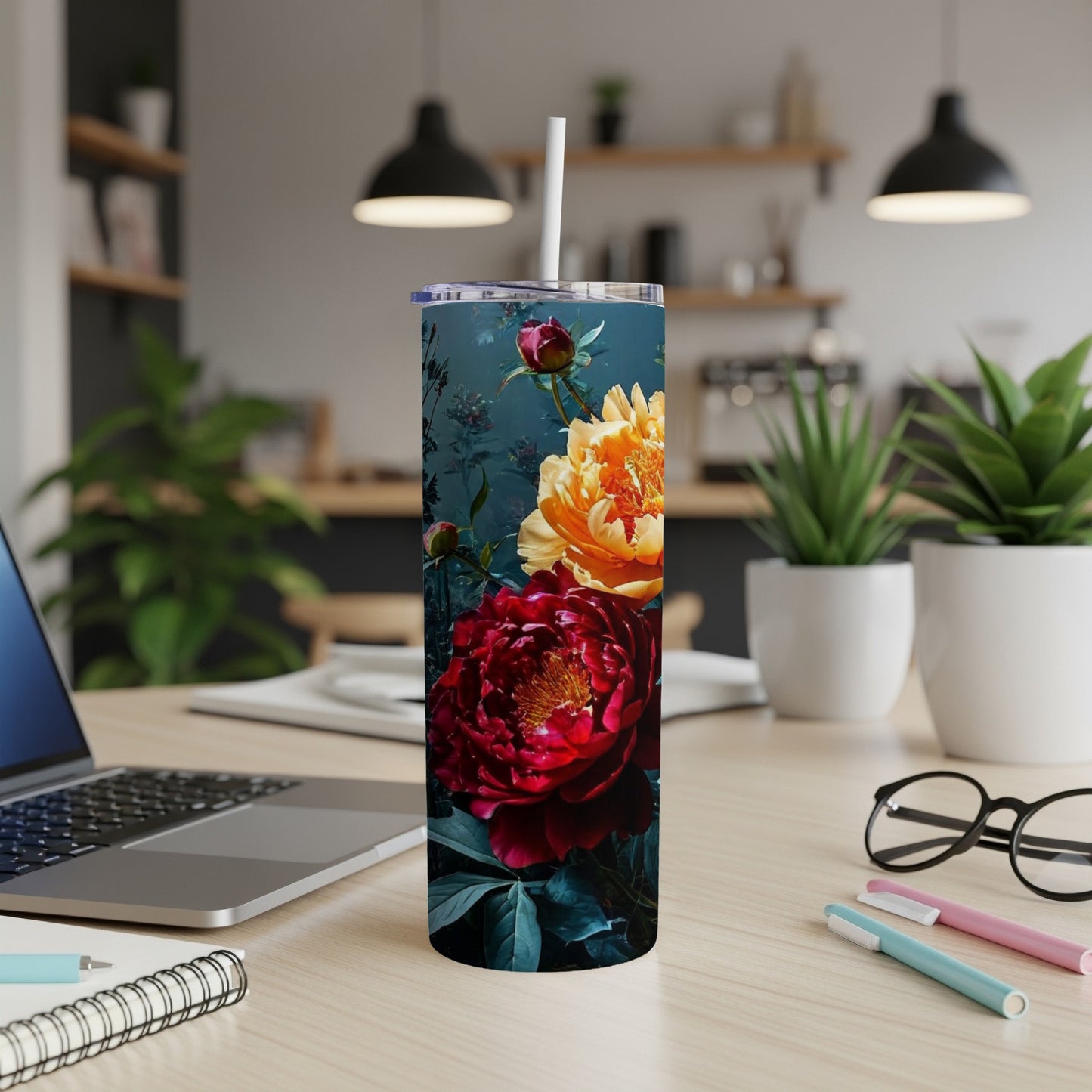 Tall tumbler with dark red and yellow peonies, set on a desk with laptop and pens.