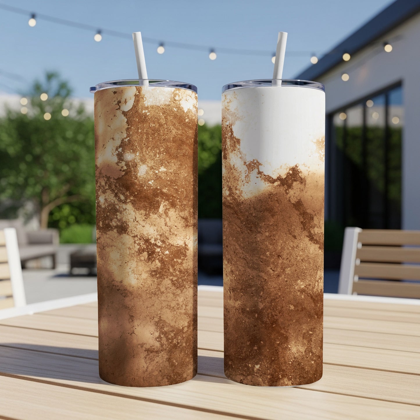 Two tall, brown and white marbled tumblers with straws on a table.