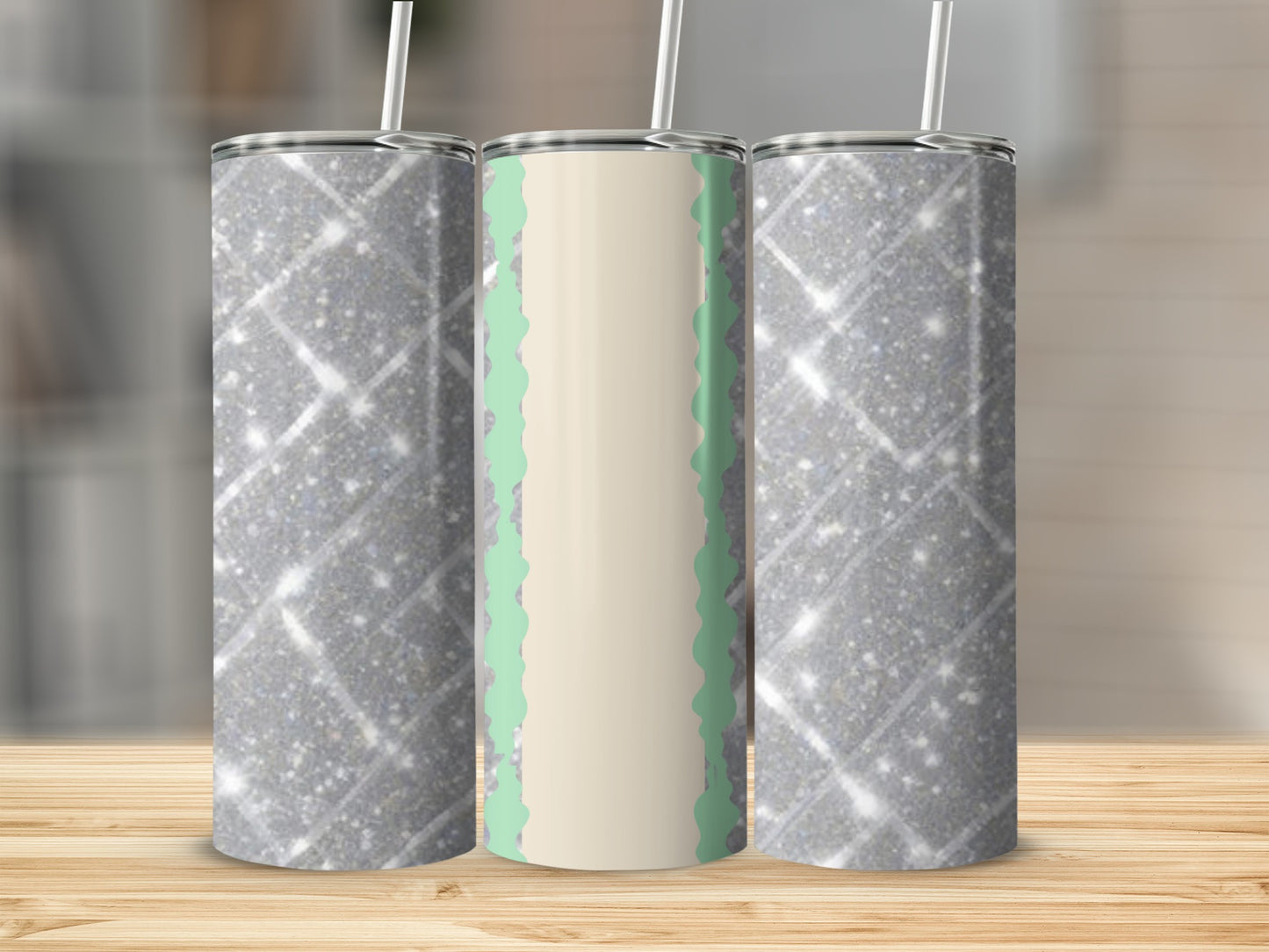 Three glittery tumblers with mint green and beige patterns on a wooden surface.