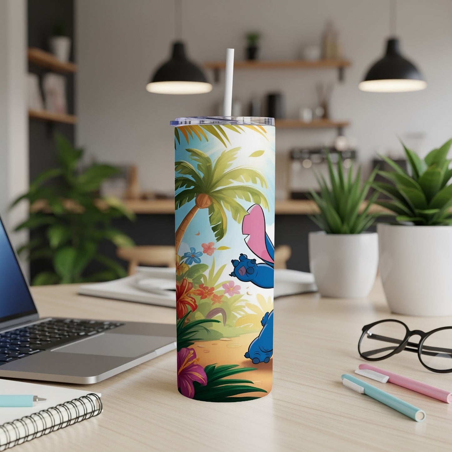 Stitch tumbler with palm trees and tropical flowers on a desk.