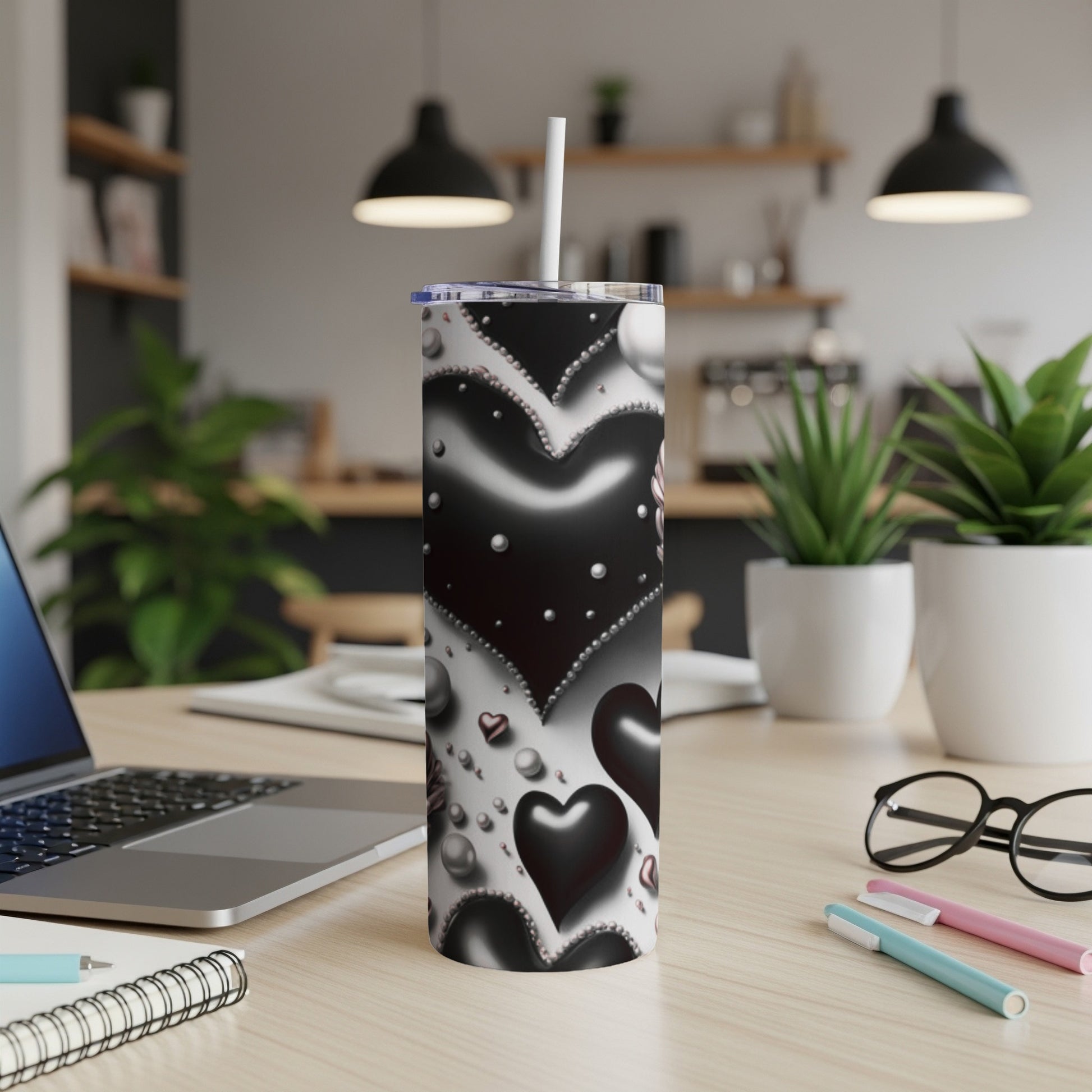 Black and white hearts pattern on a white skinny tumbler with a straw.