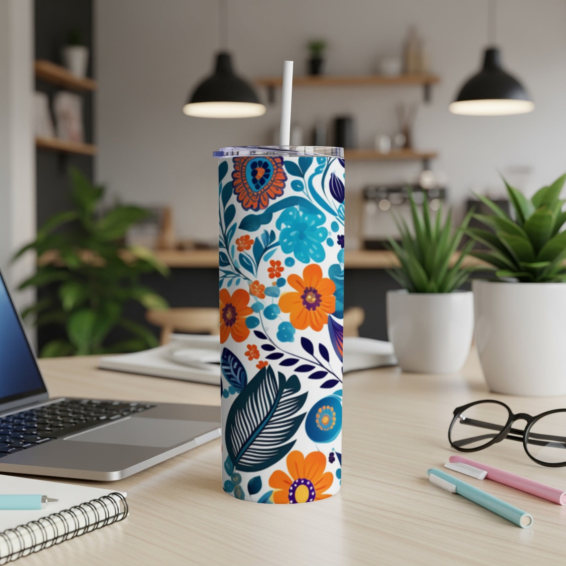 White tumbler with blue, orange, and green floral pattern.