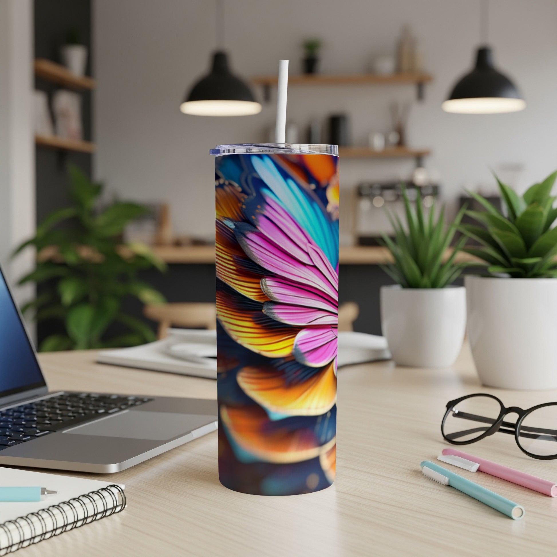 Colorful floral patterned tumbler with straw on a desk.