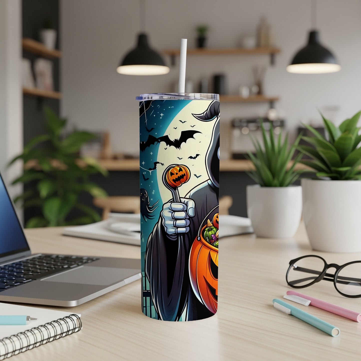 Tumbler with Grim Reaper holding pumpkin lollipop and candy bucket on a desk.