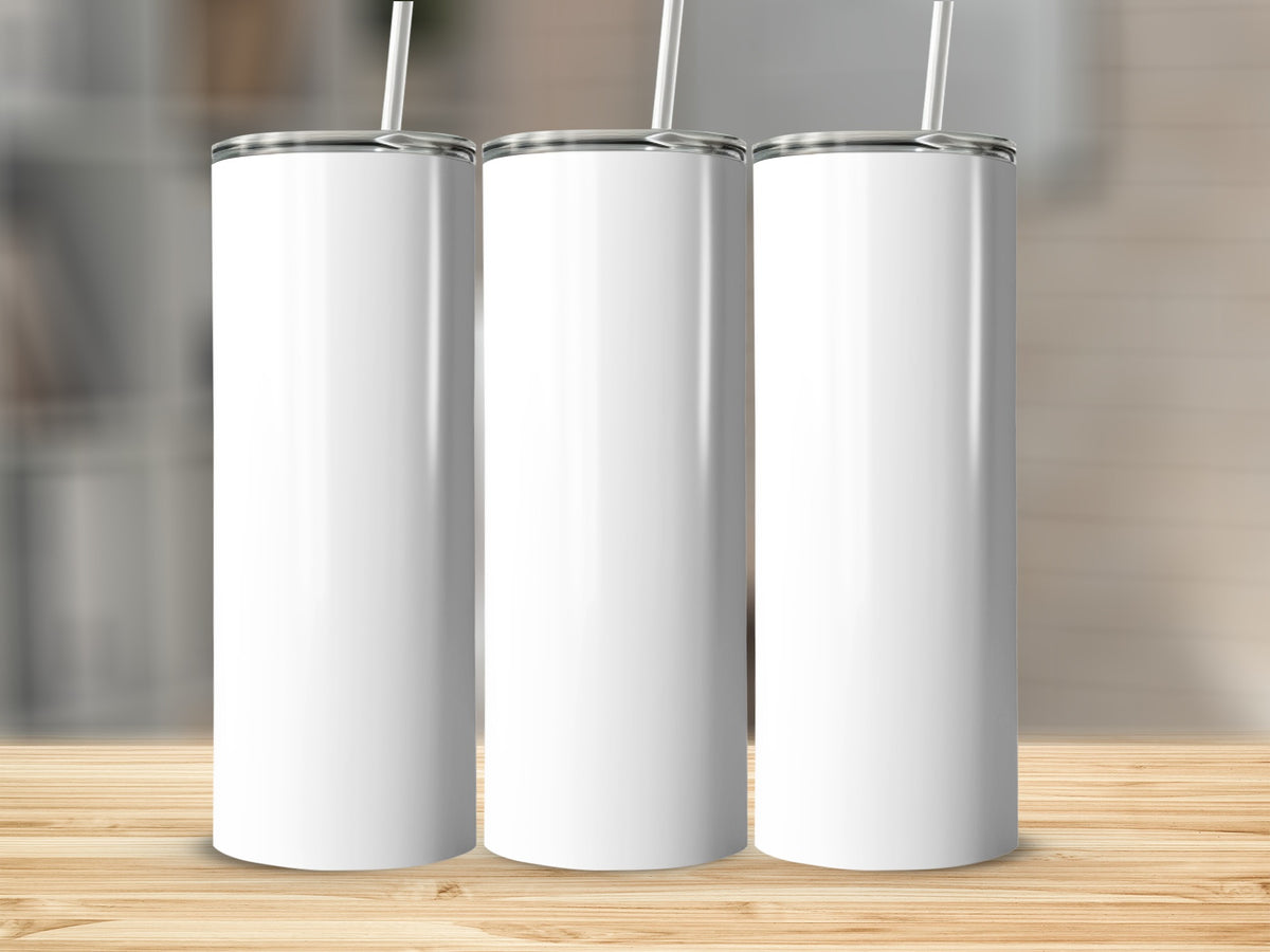 Three white, plain tumblers with straws stand on a wooden surface.