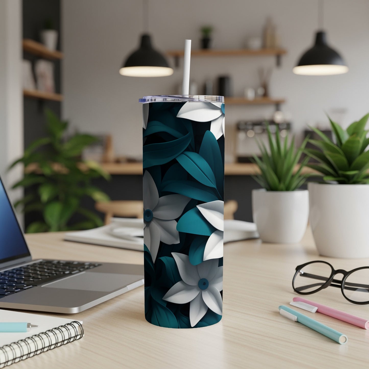 Slim tumbler with teal and white floral pattern on desk.