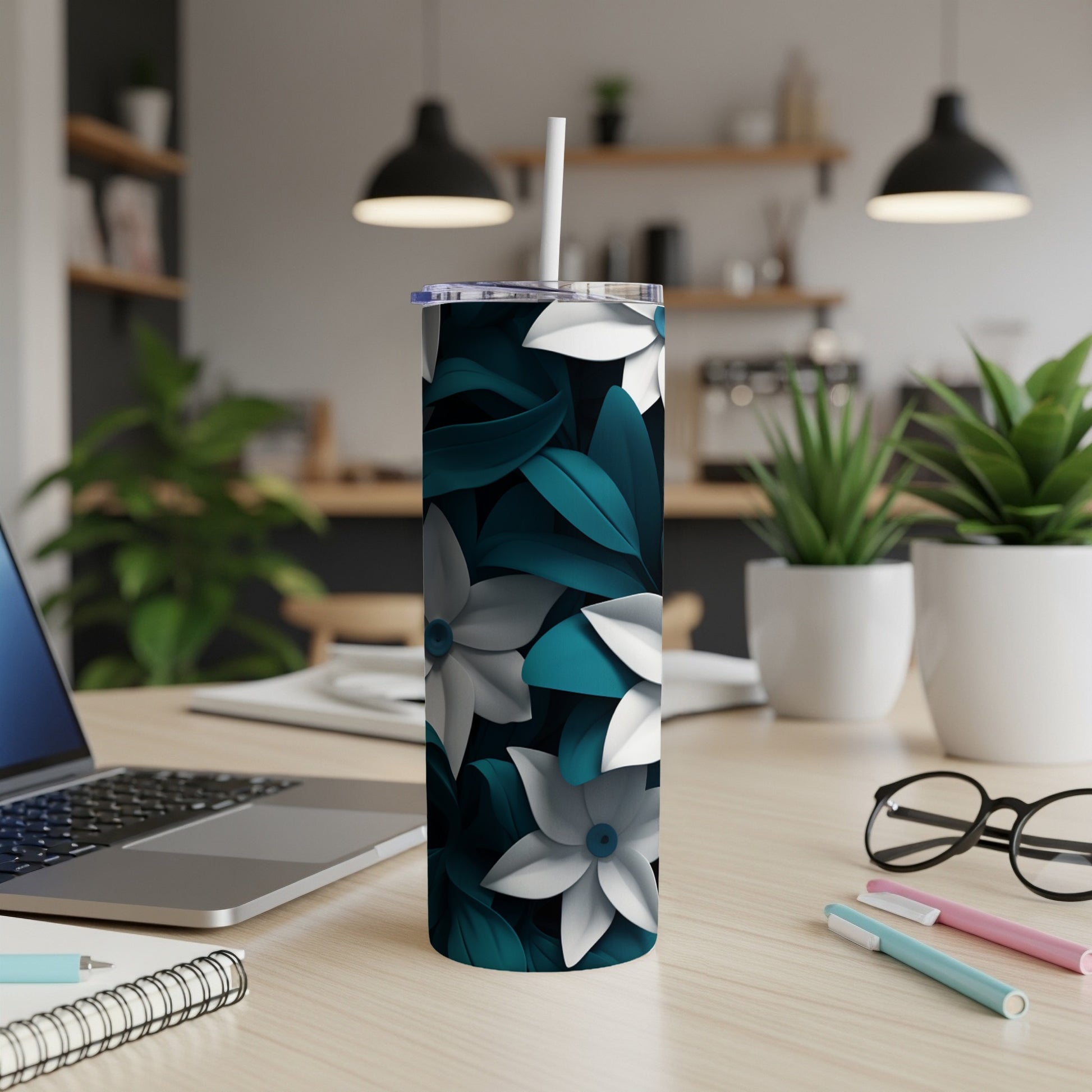 Slim tumbler with teal and white floral pattern on desk.