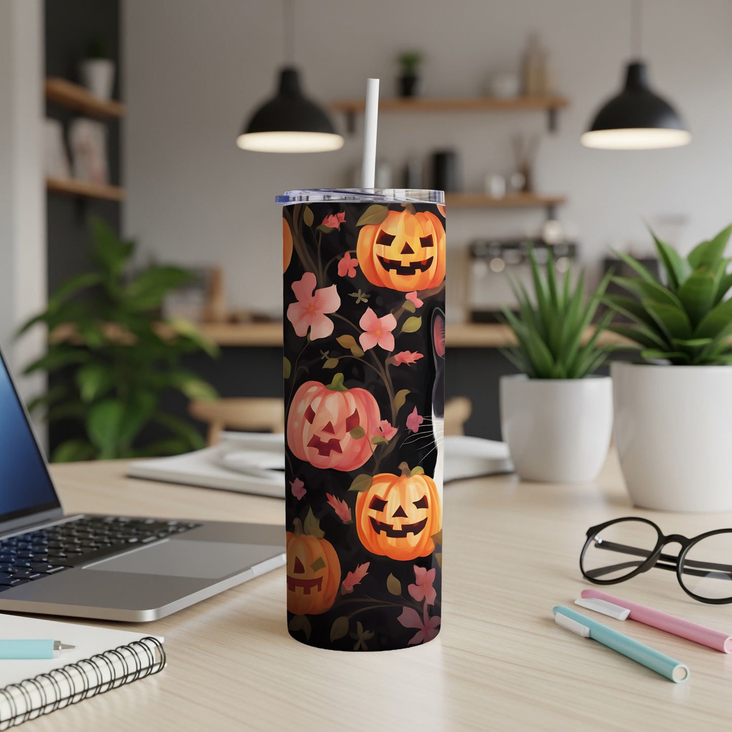 Black tumbler with Halloween pumpkins, floral pattern, and a white straw.
