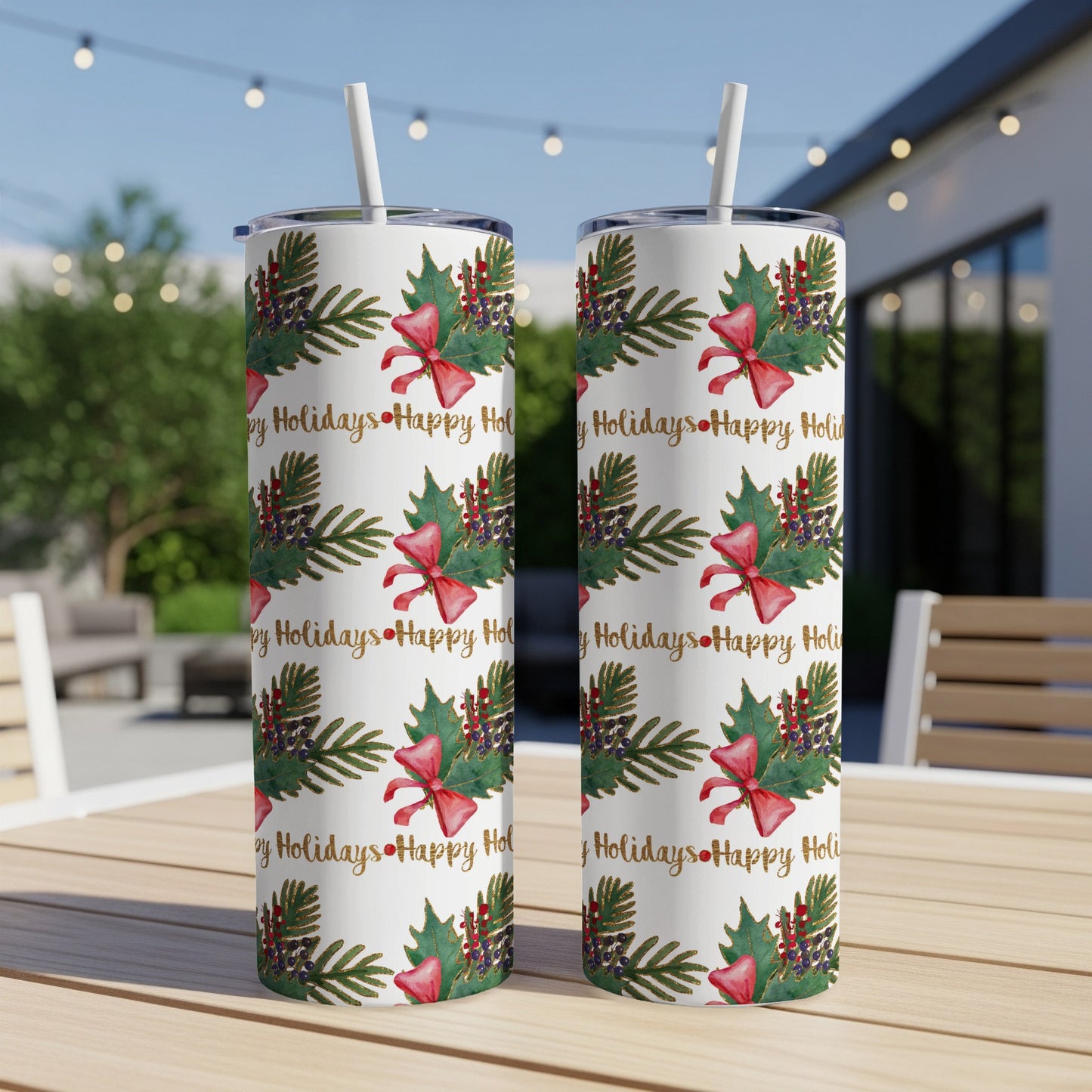 Two tumblers with repeating "Happy Holidays" pattern on a wooden table.
