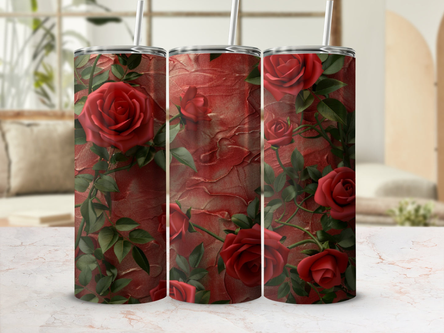 Three tumblers adorned with red roses and green leaves on a textured red background.
