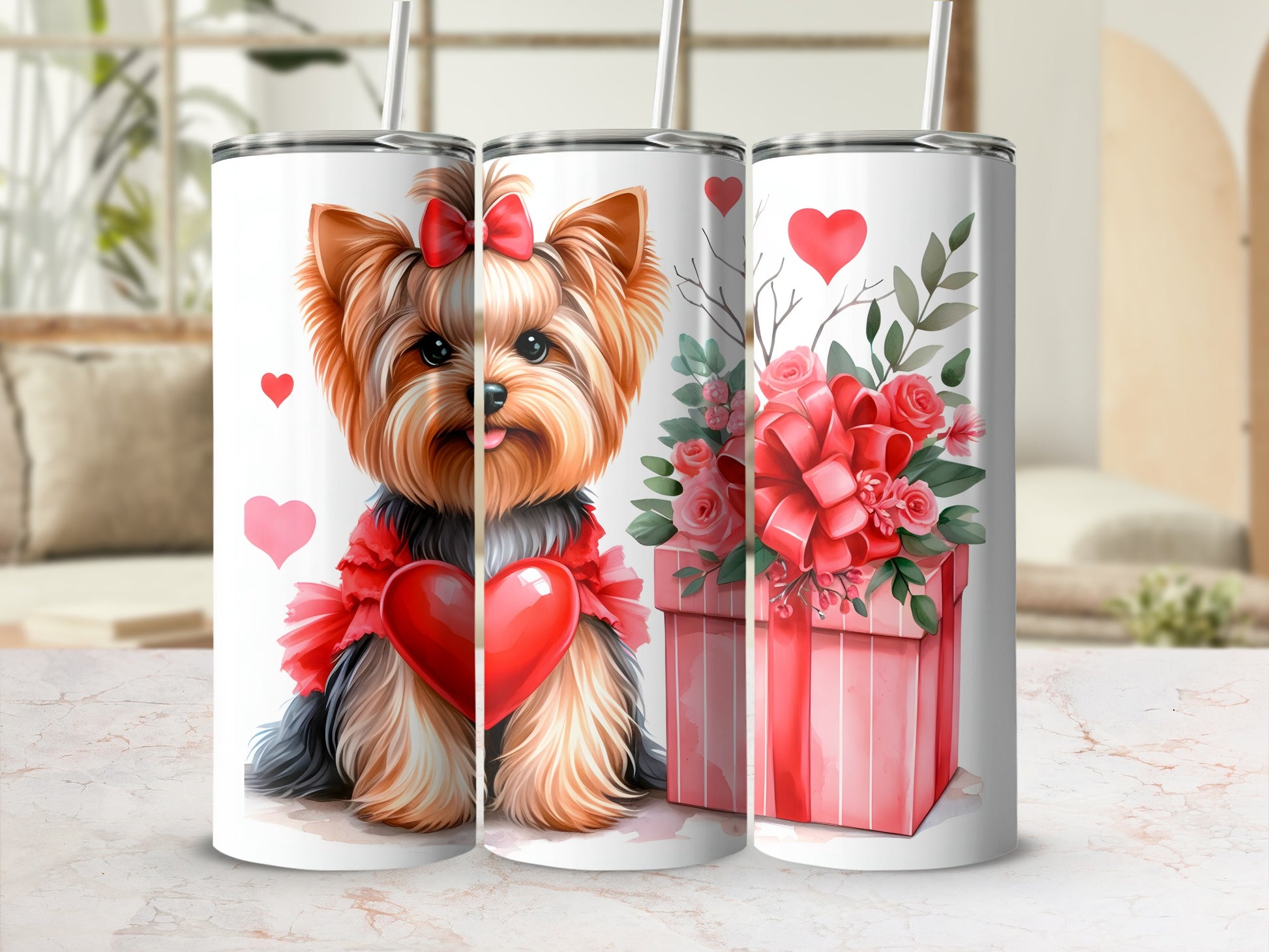 Yorkshire terrier wearing a heart garland on a tumbler next to a gift box.