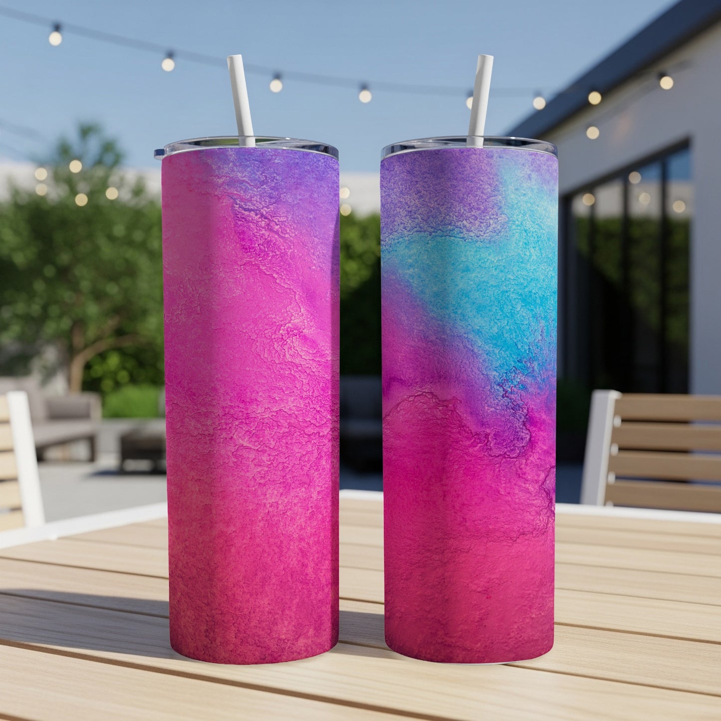 Two tumblers with a marbled pink, purple, and blue design sit on a table.