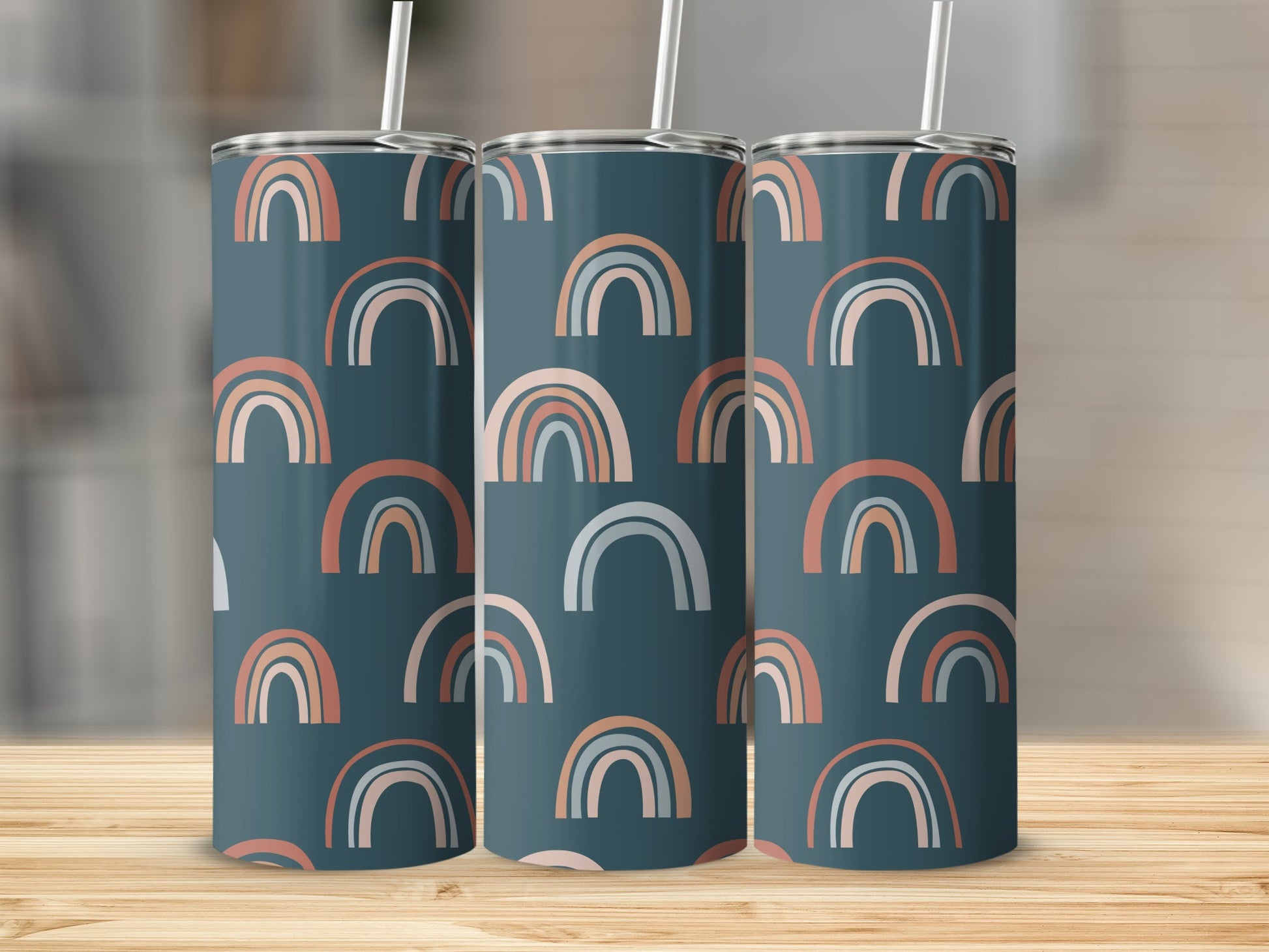 Three tumblers with a repeating abstract rainbow pattern on a dark teal background.