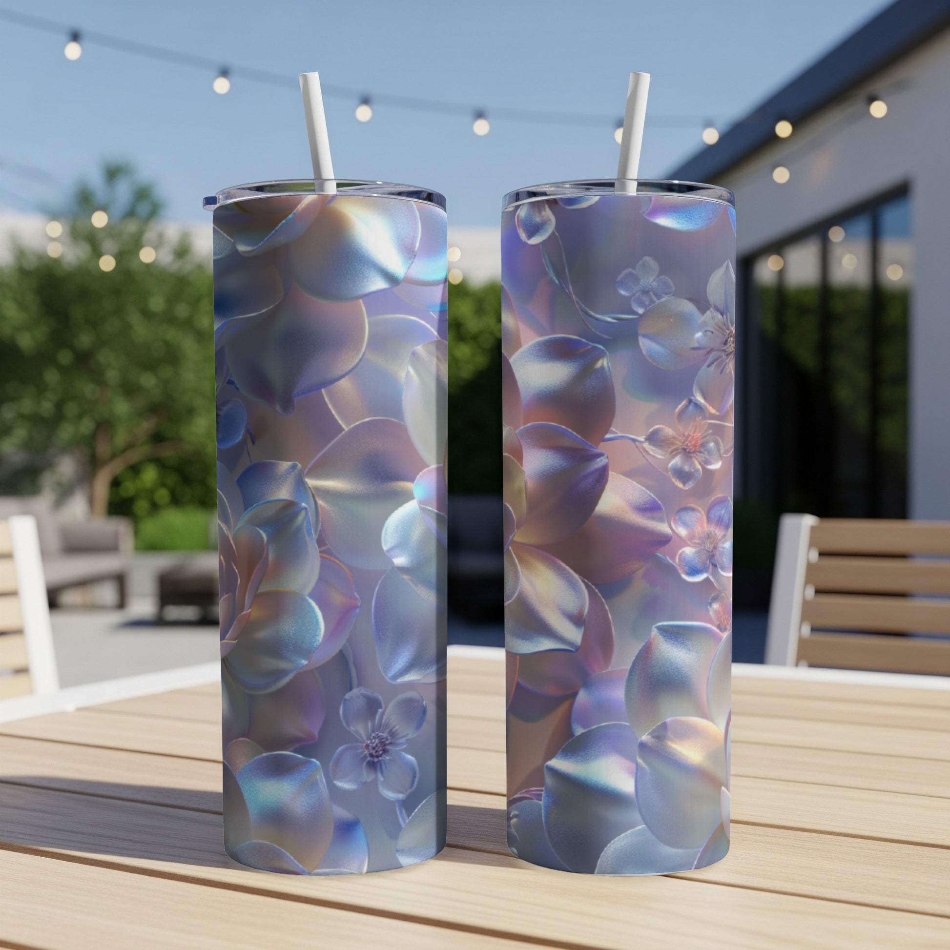 Two iridescent tumblers with floral patterns sit on a wooden table outdoors.