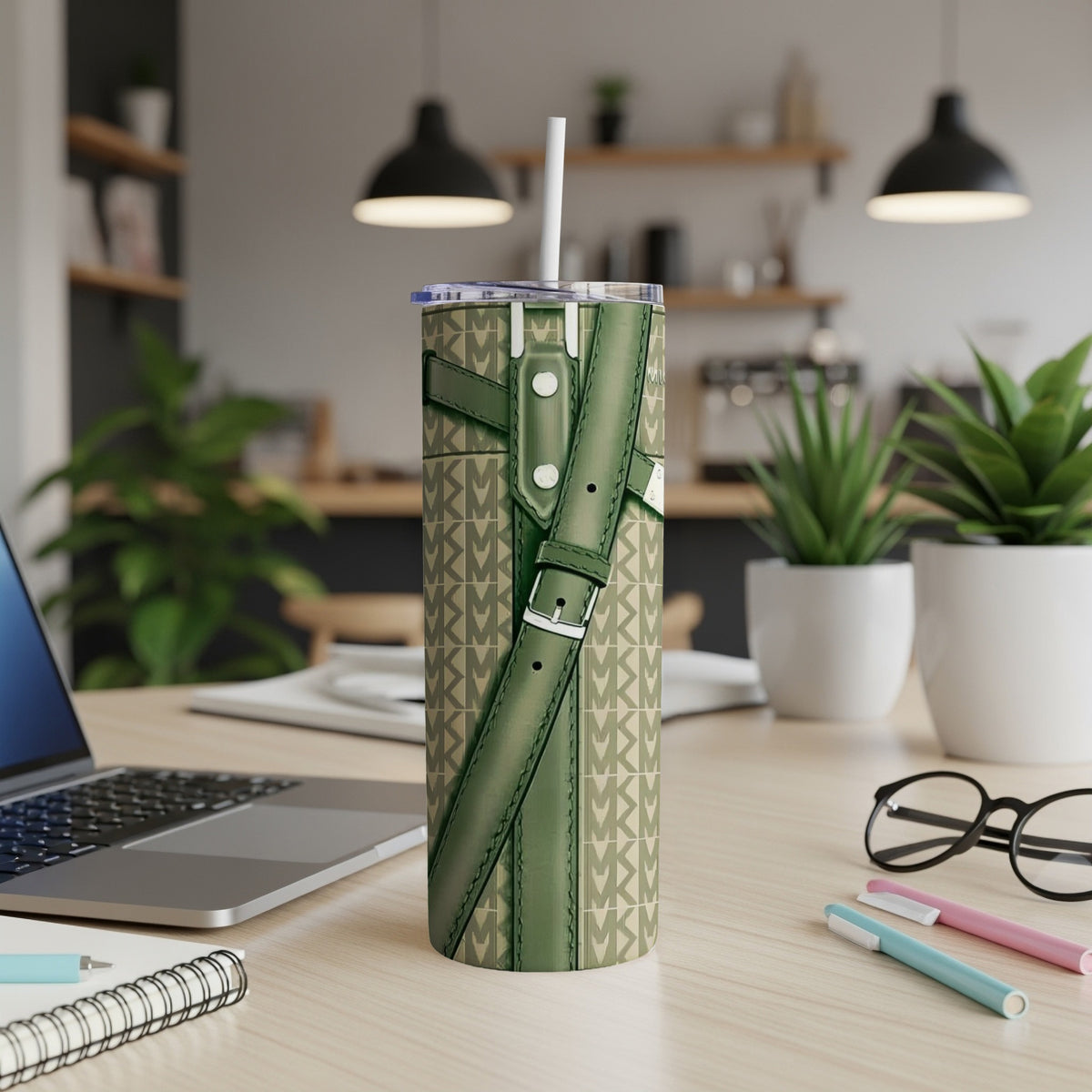 Green Michael Kors patterned tumbler with straps on a desk.