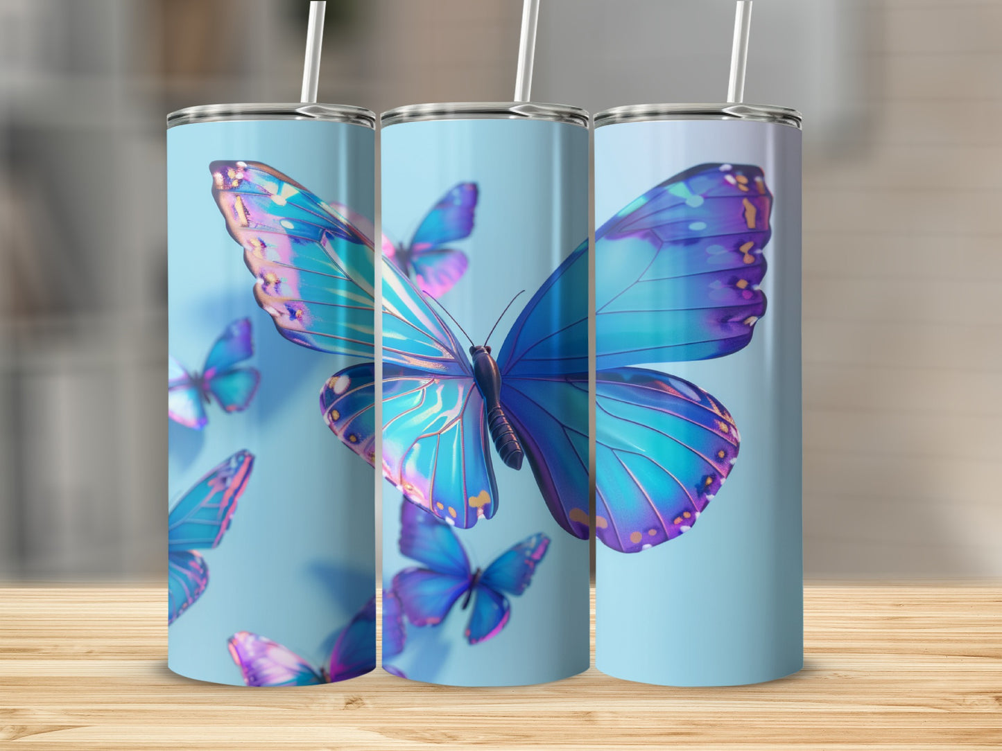Three tumblers with iridescent blue butterfly designs on a light blue background.