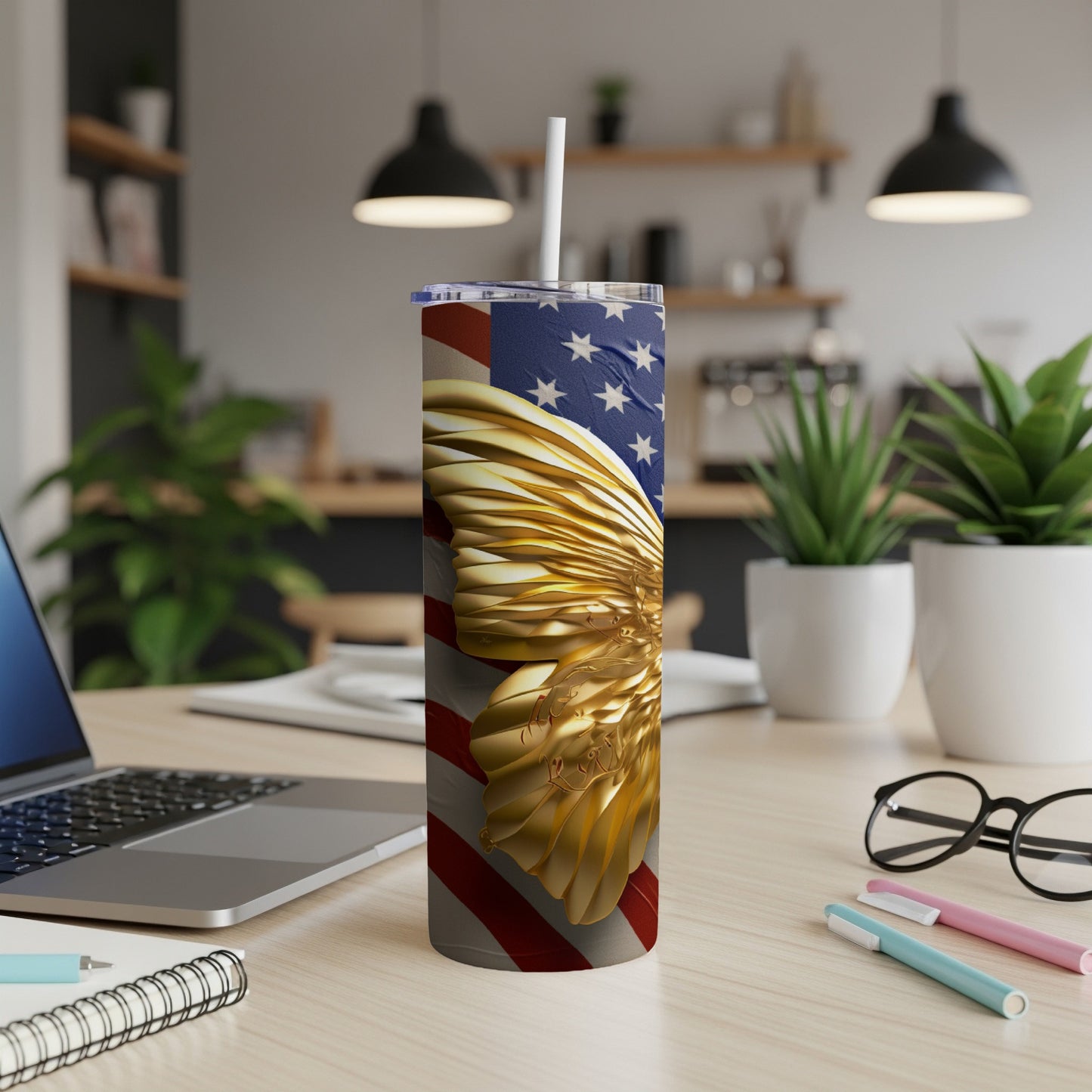 American flag tumbler with golden eagle wings on a desk.