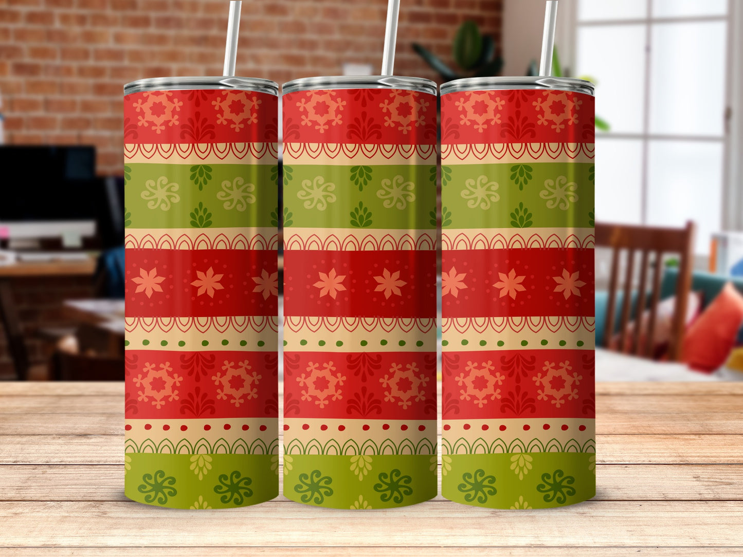 Three red, green, and gold striped tumblers with festive patterns on a wooden surface.