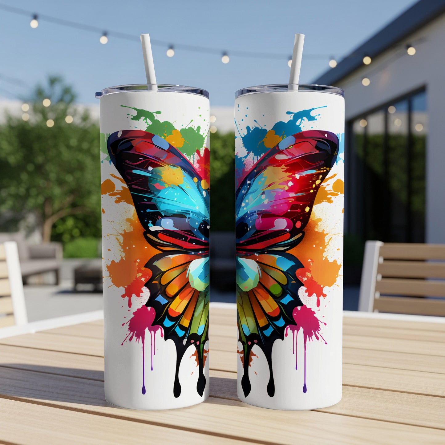 Two tumblers with vibrant butterfly wing design and paint splatters.