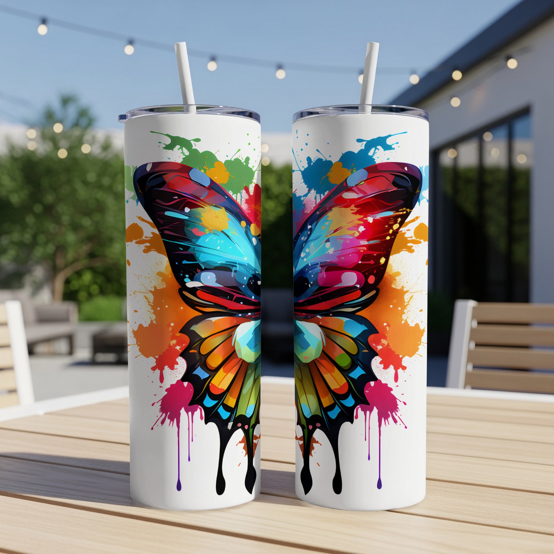 Two tumblers with vibrant butterfly wing design and paint splatters.