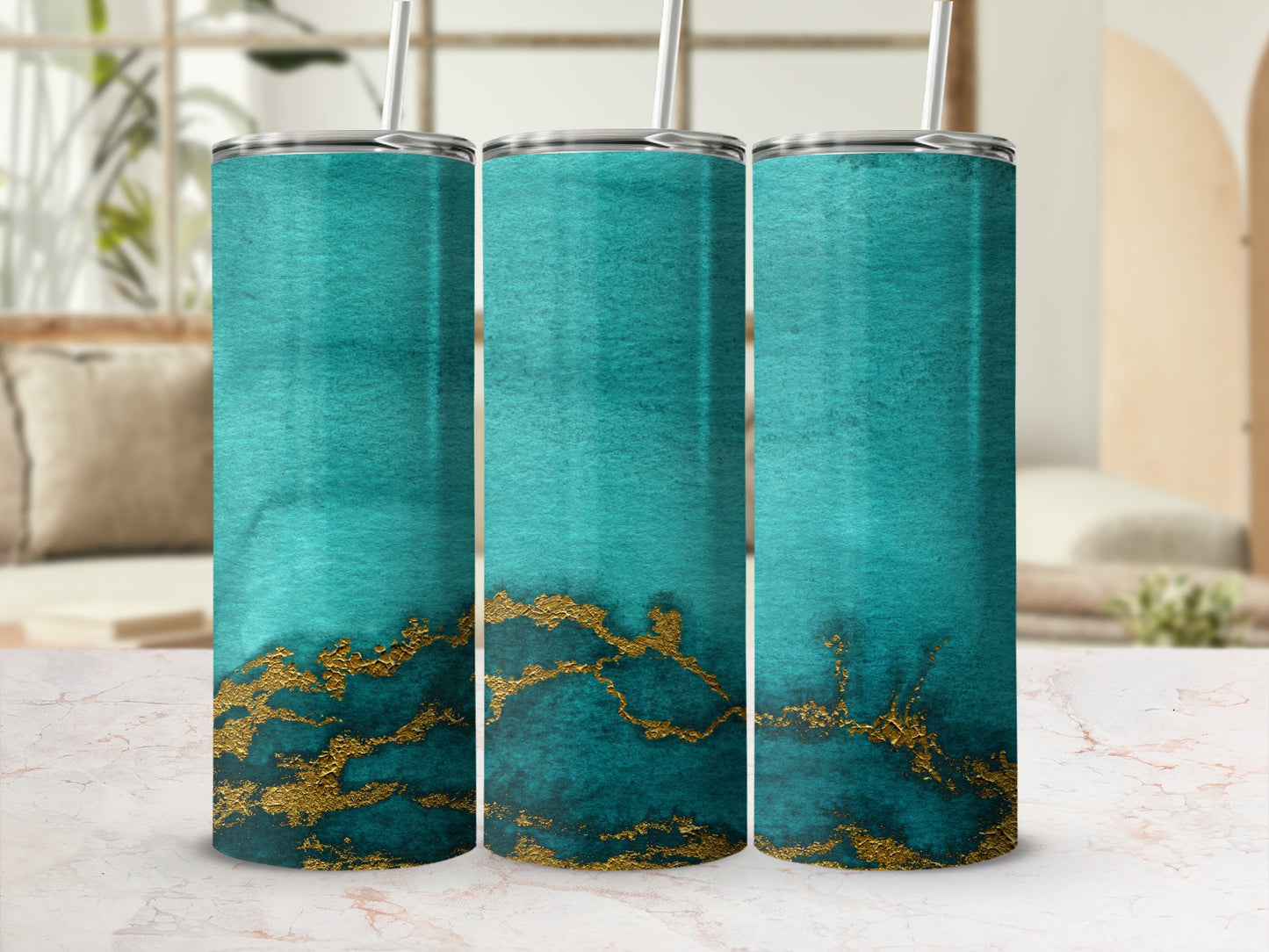 Three teal tumblers with gold marble pattern and straws.