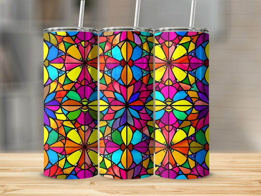 Three colorful stained glass tumblers with straws on a wooden surface.