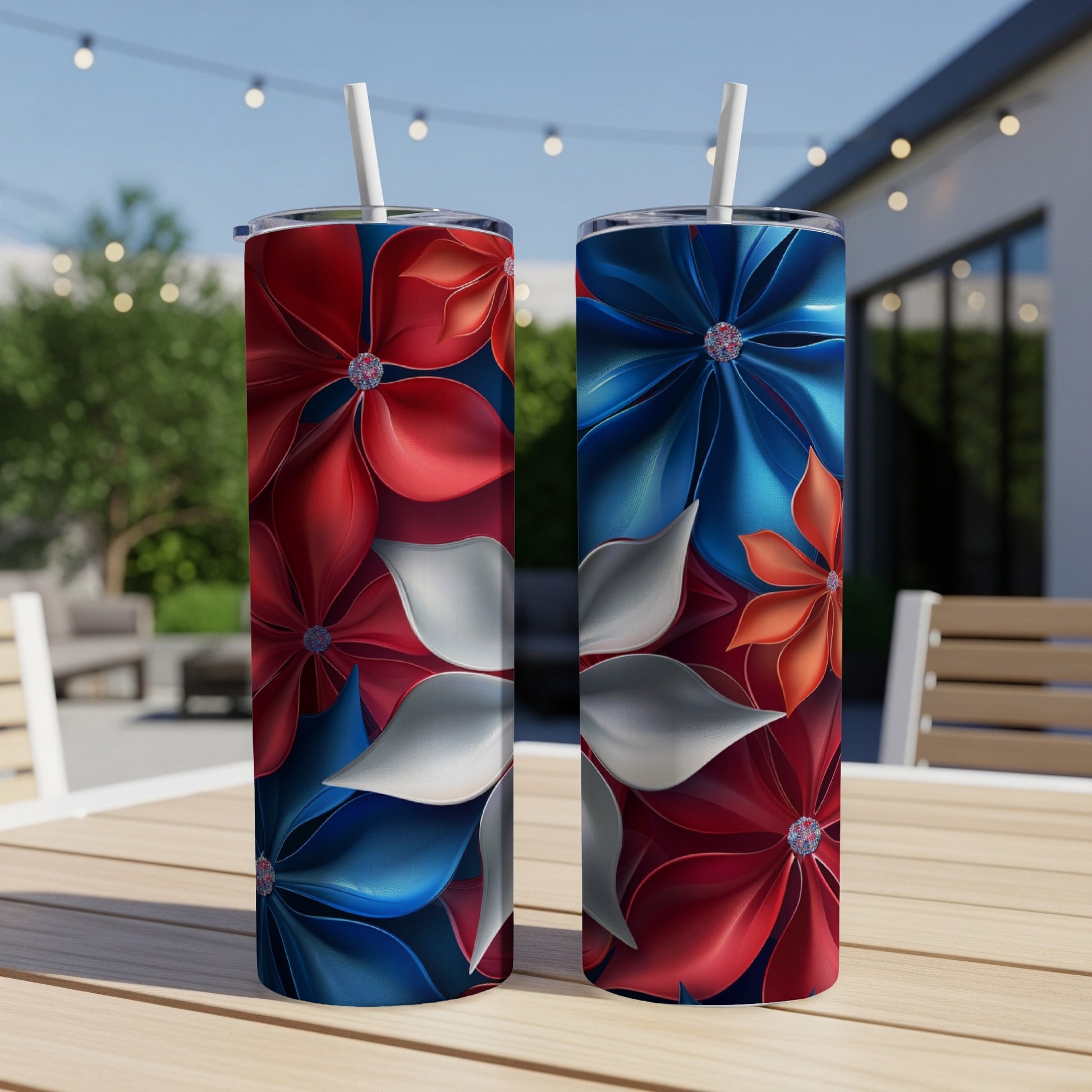 Two tall tumblers with red, white, and blue floral designs sit on a table.
