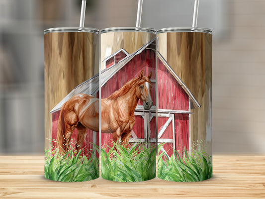 Brown horse standing in front of red barn with green grass.